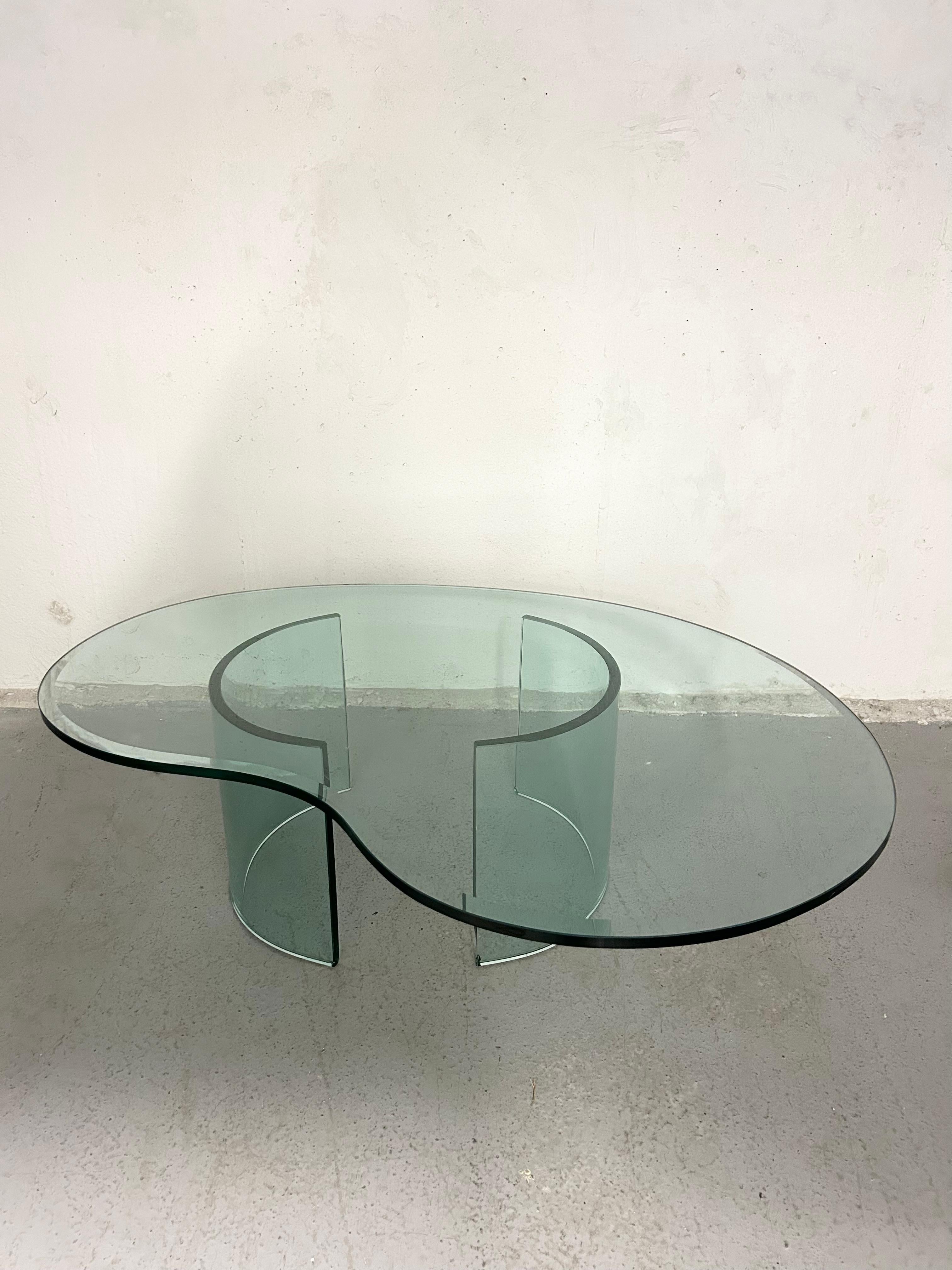 Vintage sculptural glass coffee table. Thick beveled glass top sits on two curved glass bases. You can move the bases around to play with proportion. No chips in the top glass, there are a few chips on the bottom corners but wouldn’t be too