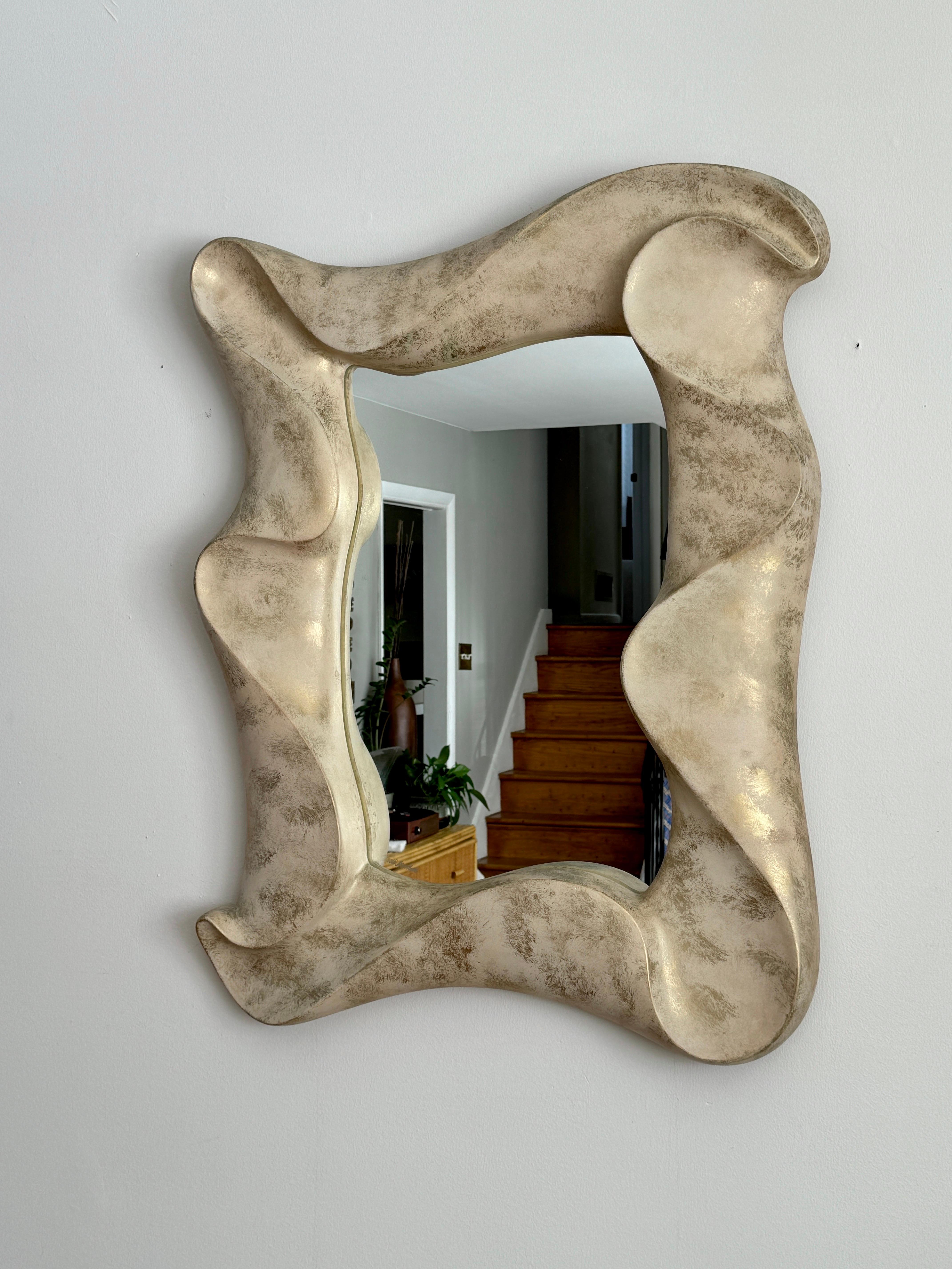Unique statement wave-like mirror crafted by renowned artist David Marshall, featuring a stunningly sculpted stone-inspired aesthetic. Signed by the artist in the lower left corner. 