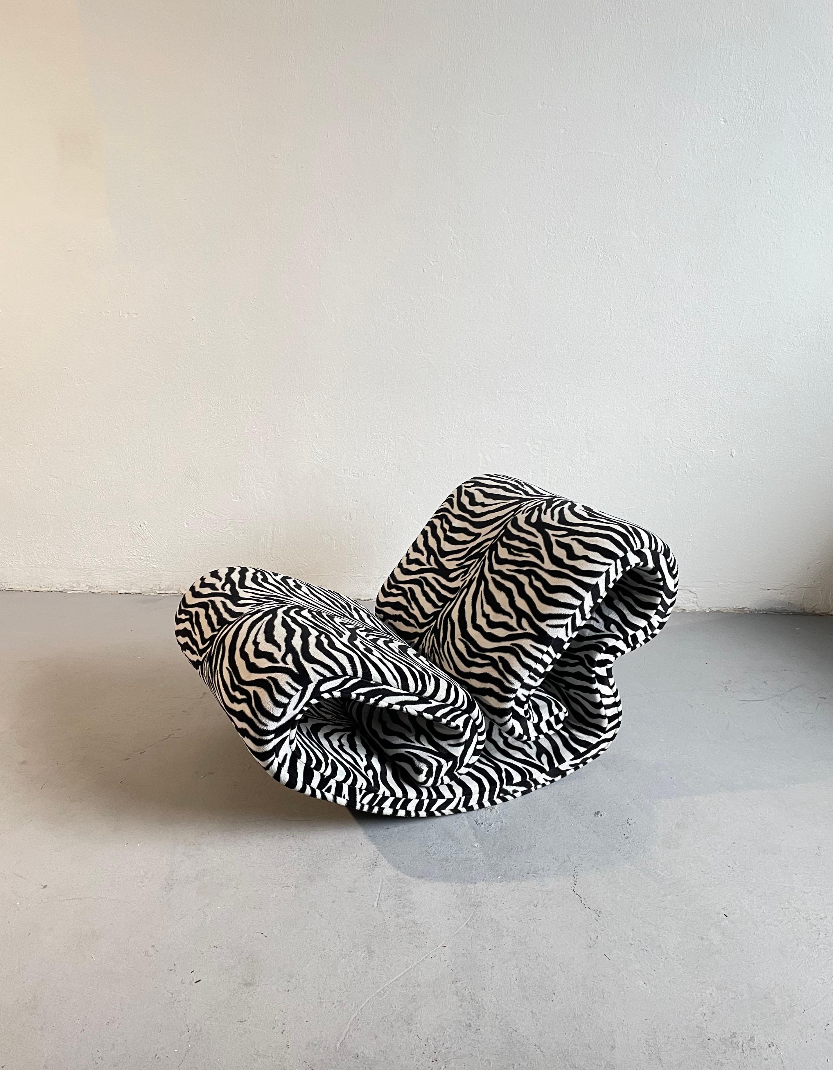 Vintage rocking lounge chair upholstered in fabric with zebra pattern

Unknown producer

Age: circa 1970s

The heavy frame is made of metal and plywood, padded and upholstered in fabric

Condition: the chair is in good used condition, with