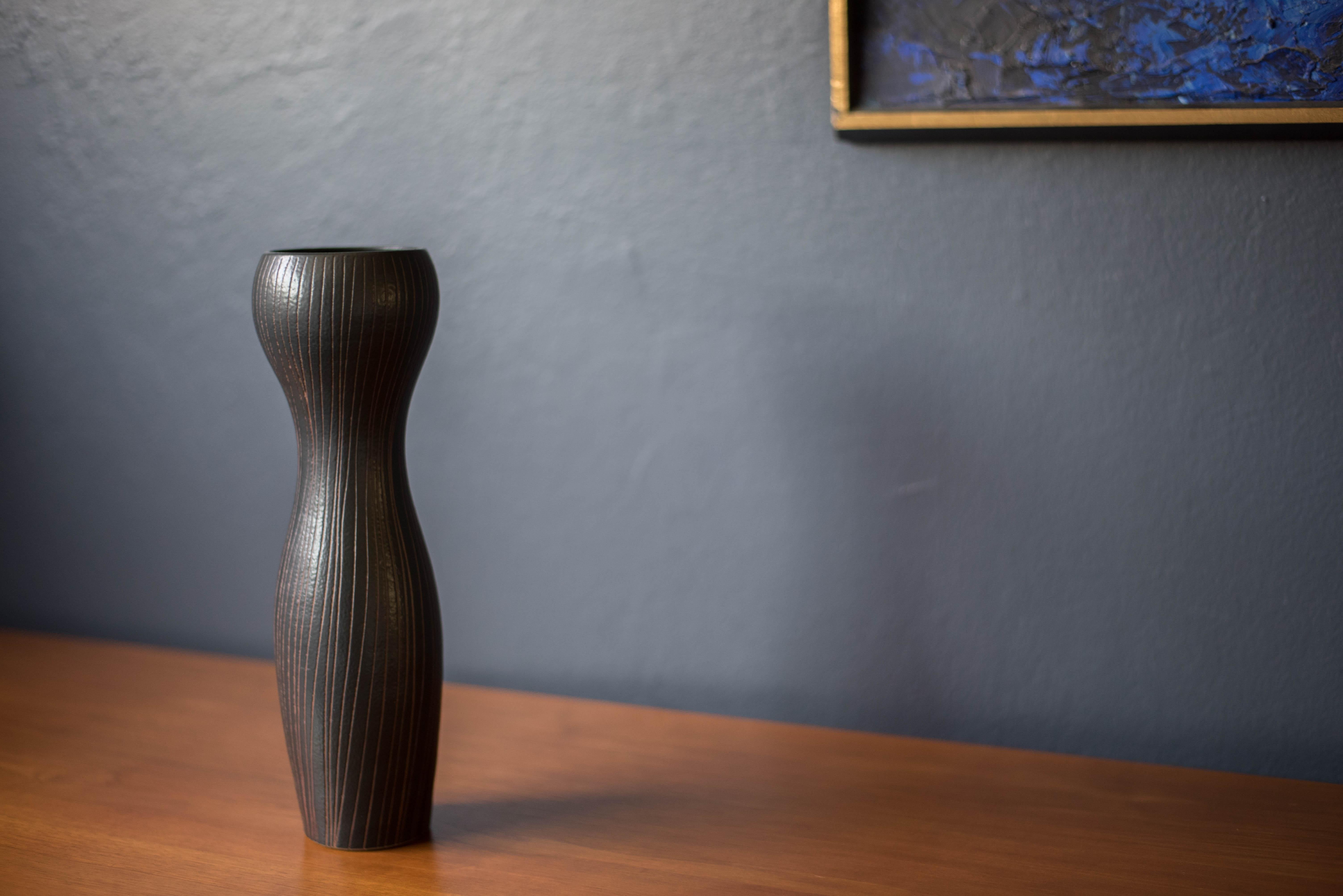 Vase en céramique de style moderne du milieu du siècle par Otagiri Mercantile Company, vers les années 1960. Ce récipient unique présente une forme sculpturale en grès avec des incisions décoratives naturelles dans une finition noire mate.