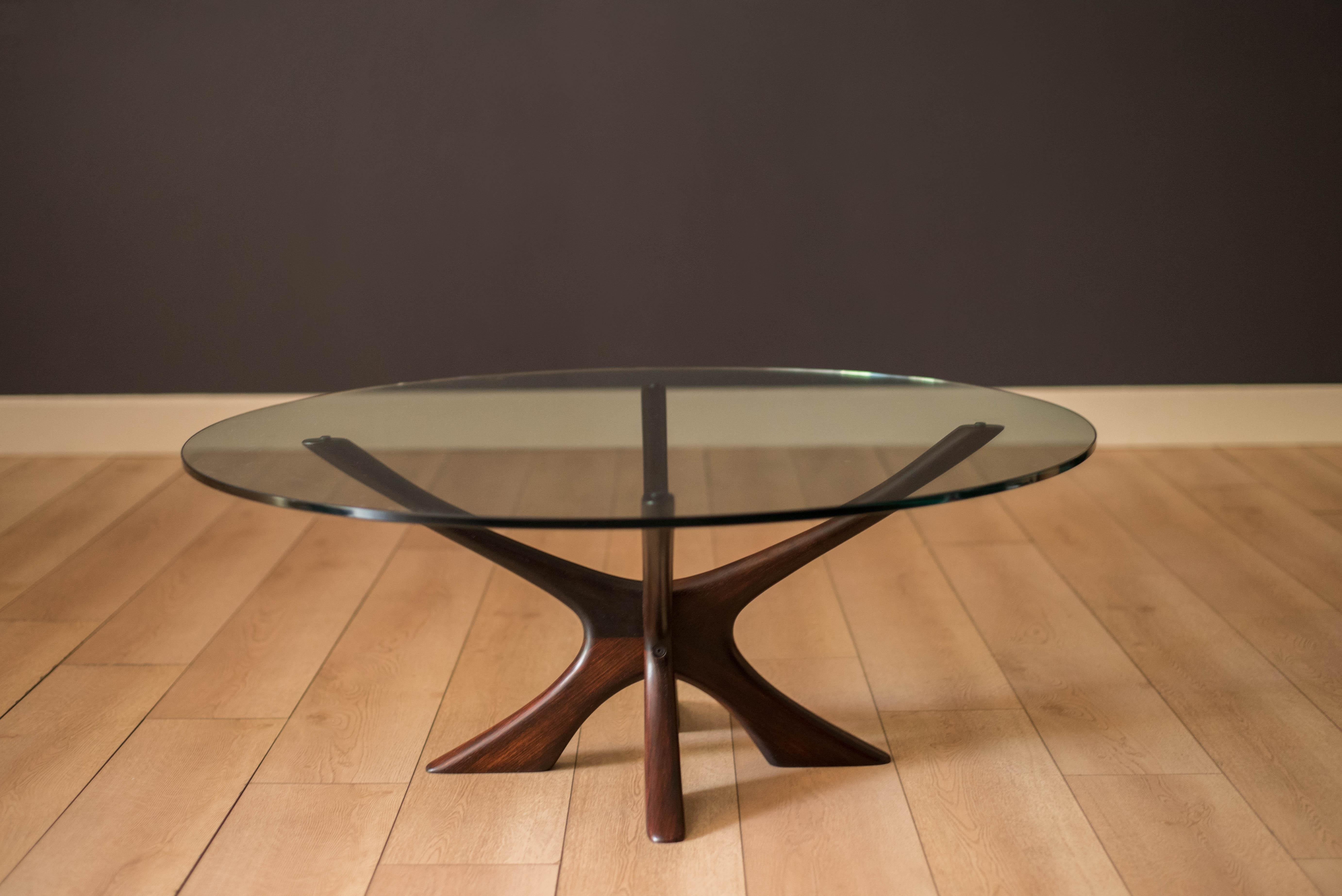 Mid-Century Modern coffee table designed by Illum Wikkelso for CFC Silkeborg, Denmark circa 1960s. Features a sculptural solid rosewood base and the original round glass top that showcases from any angle in the room. 

Glass top 1/2