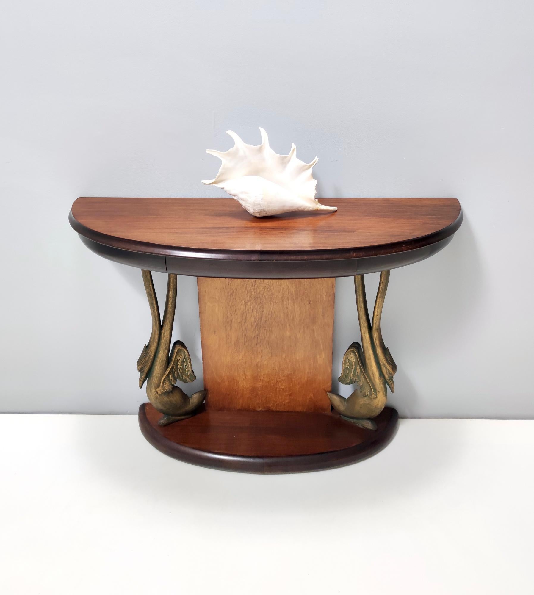 Made in Italy, 1950s. 
This is a high-quality console table, which is made in dyed Canaletto walnut and beech. 
It features two carved swans next to the pedestal.
This is a vintage piece, therefore it might show slight traces of use, but it can be