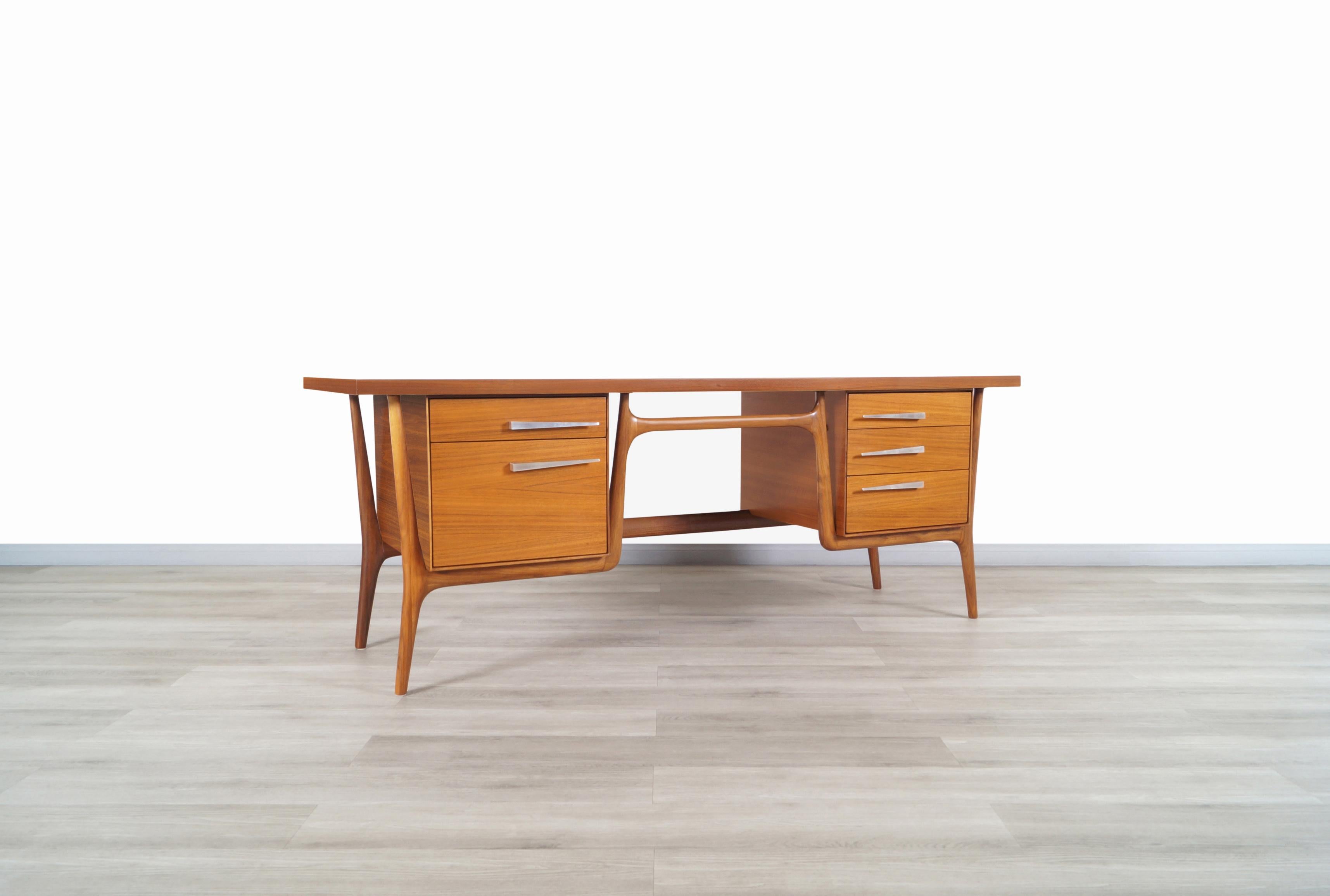 Amazing vintage sculptural walnut desk designed and manufactured by Leopold Co. of Burlington in the United States, circa 1950s. This desk has an avant-garde design combined with the finest of walnut results in a distinctive piece of furniture. The