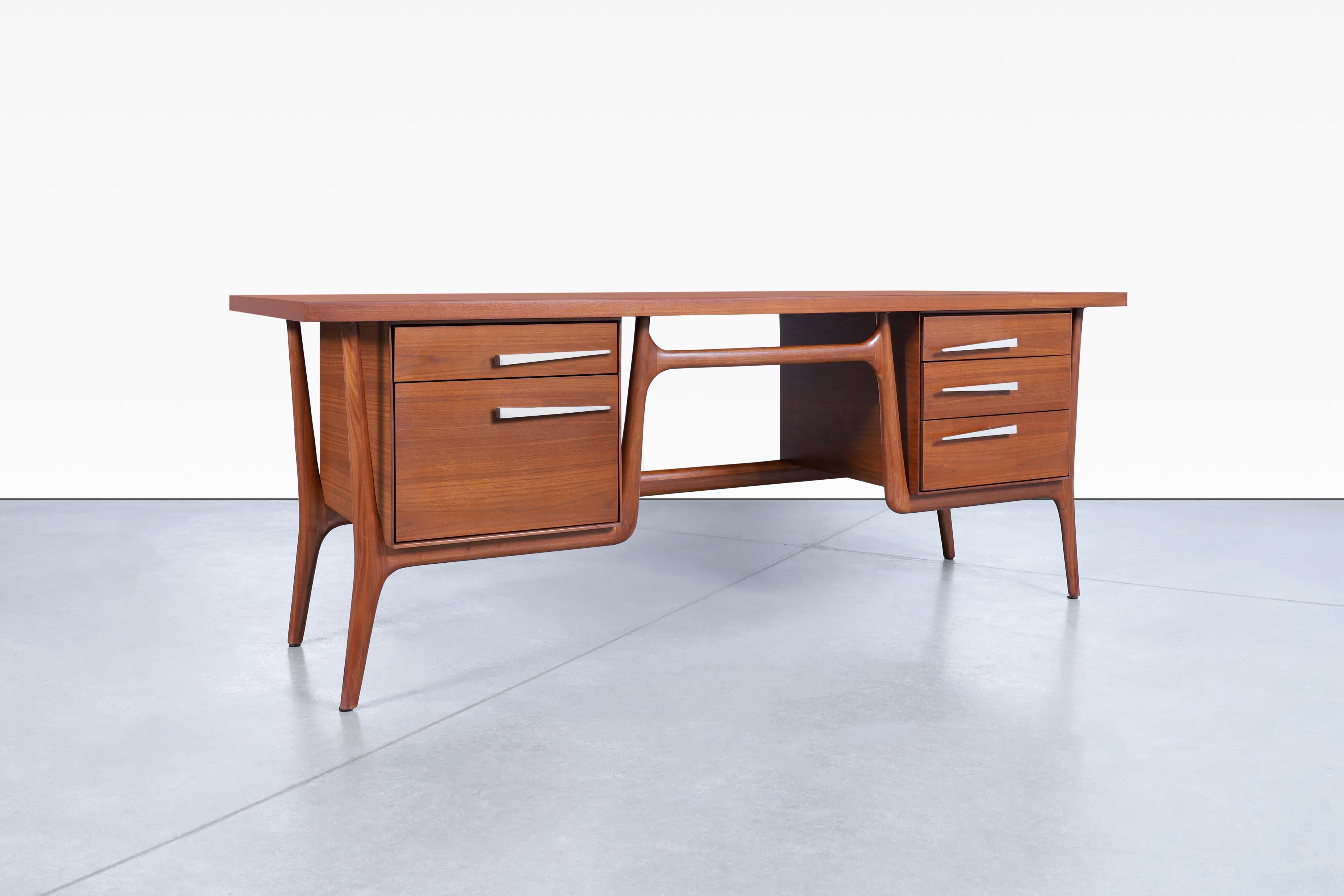Stunning vintage sculptural walnut desk designed and manufactured by Leopold Co. of Burlington in the United States, circa 1950s. This desk has an avant-garde design combined with the finest of walnut results in a distinctive piece of furniture. The