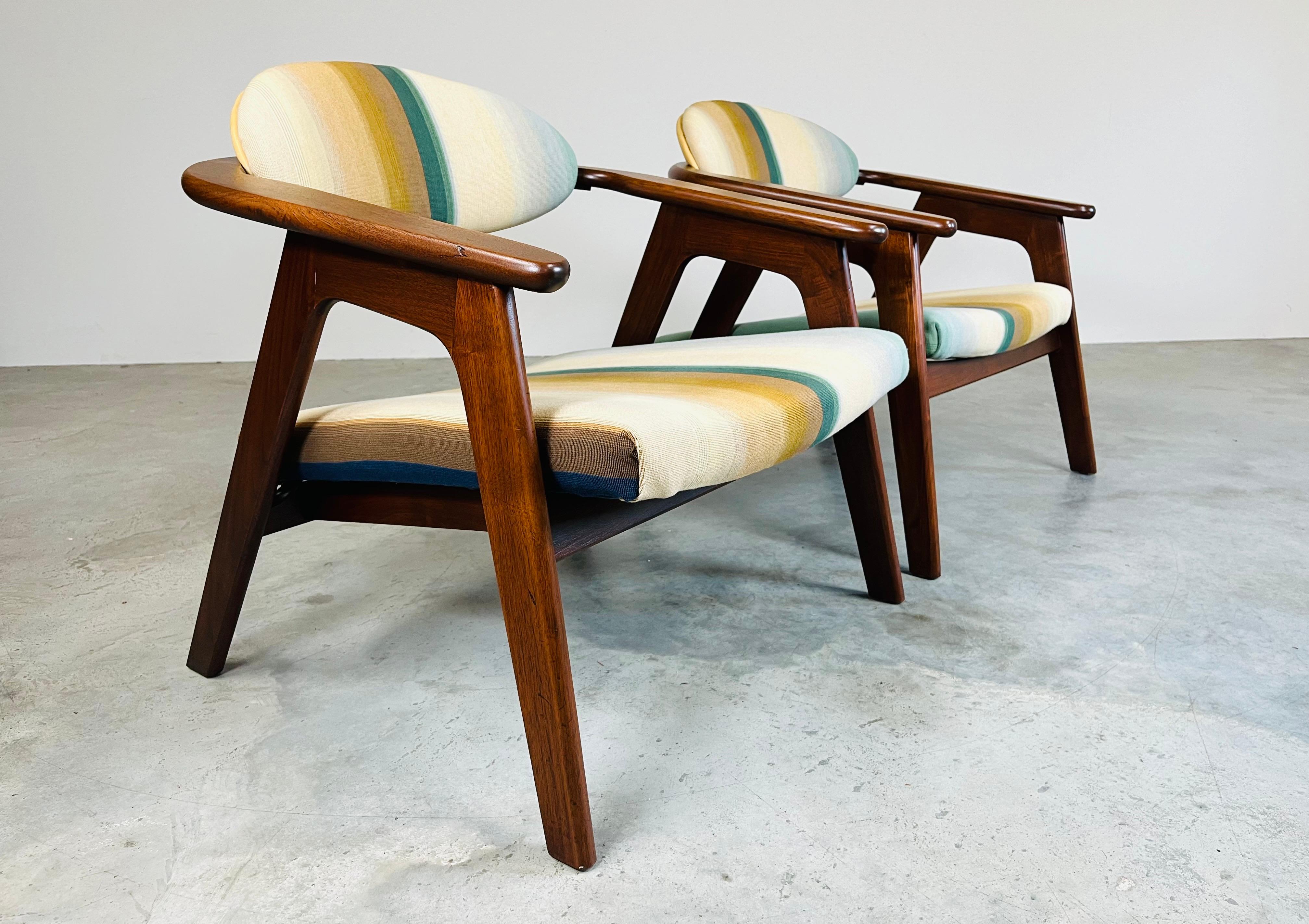 A sculptural pair of ‘Captains’ chairs Model #916-CC having walnut frames, striking Maharam's Paul Smith epingle stripe upholstery with vegetable dyed aniline leather backs designed by Adrian Pearsall for Craft Associates.
North America ca 1960.
In
