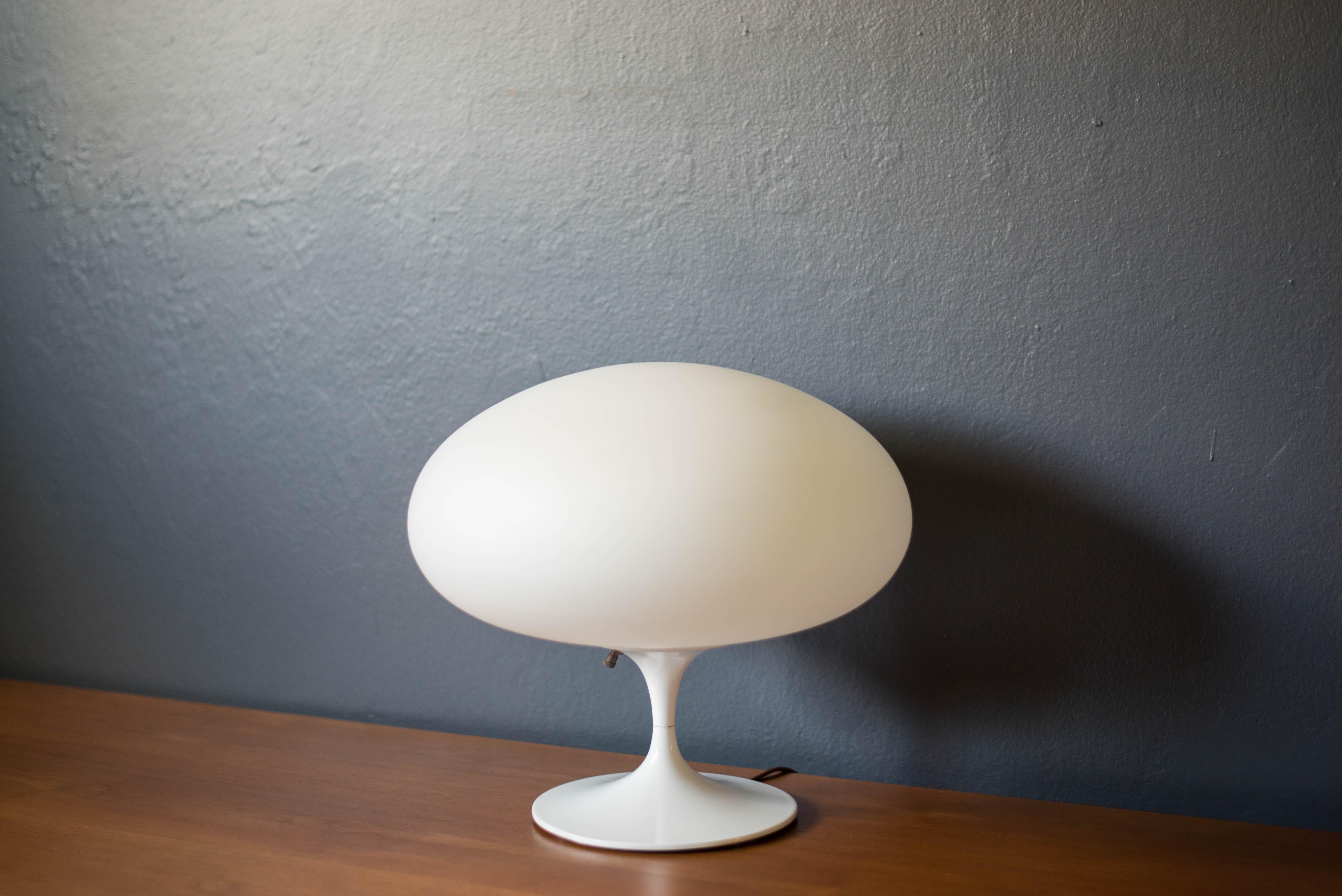 Mid century modern accent table lamp manufactured by Laurel Lamp Co. circa 1960's. This unique piece features a sculptural tulip base in a white enamel finish equipped with a three way switch mechanism. This space age design includes the original