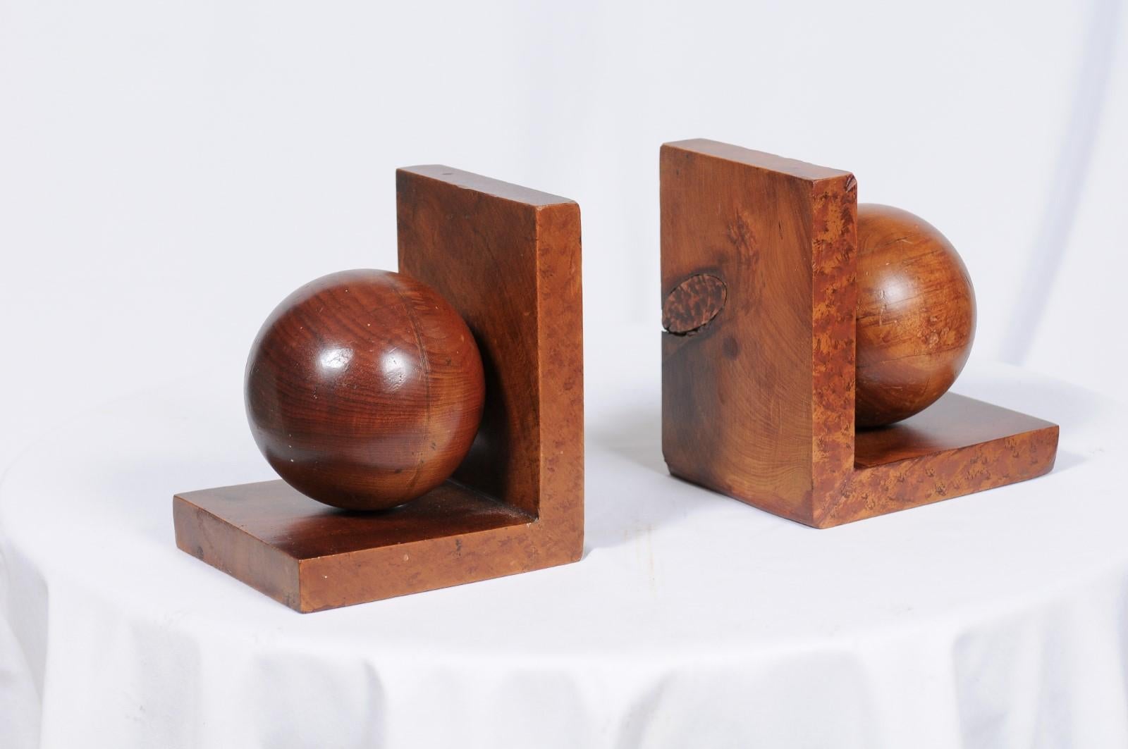 Vintage wood bookends featuring a large ball nestled within the frame of the bookend, and featuring both burled and finely grained woods. Classic, clean, and contemporary!