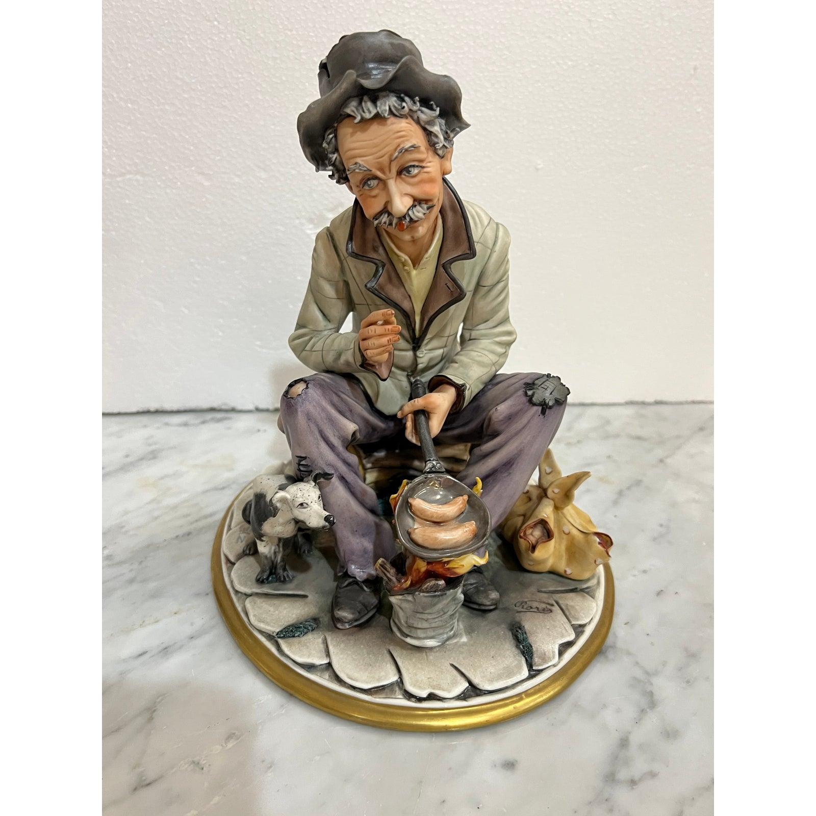 Vintage Hand-Paintted Roris Sculpture Artistiche Man on Bench cooking hot dog on campfire made in Italy. Précieuse pièce d'art bien sculptée. les détails du vêtement robuste de l'homme attirent l'attention.

Condit est d'occasion mais en excellent