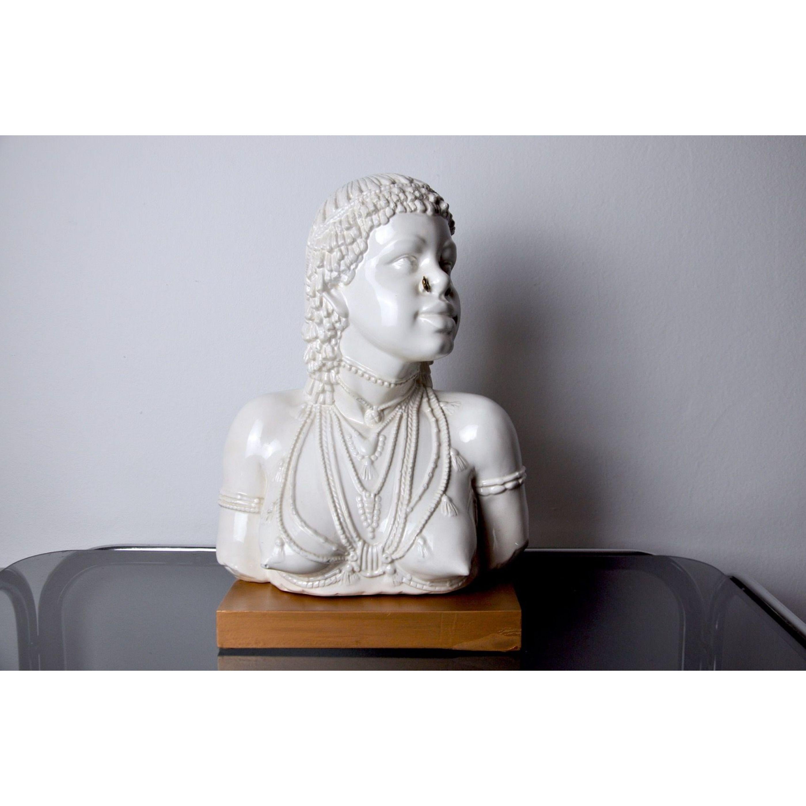 Very nice and large white ceramic bust representing an aborigine. This bust was designed and produced in Italy in the 70s. Wooden base, golden metal piercing. A rare decorative object because of its design and its large size. 

 