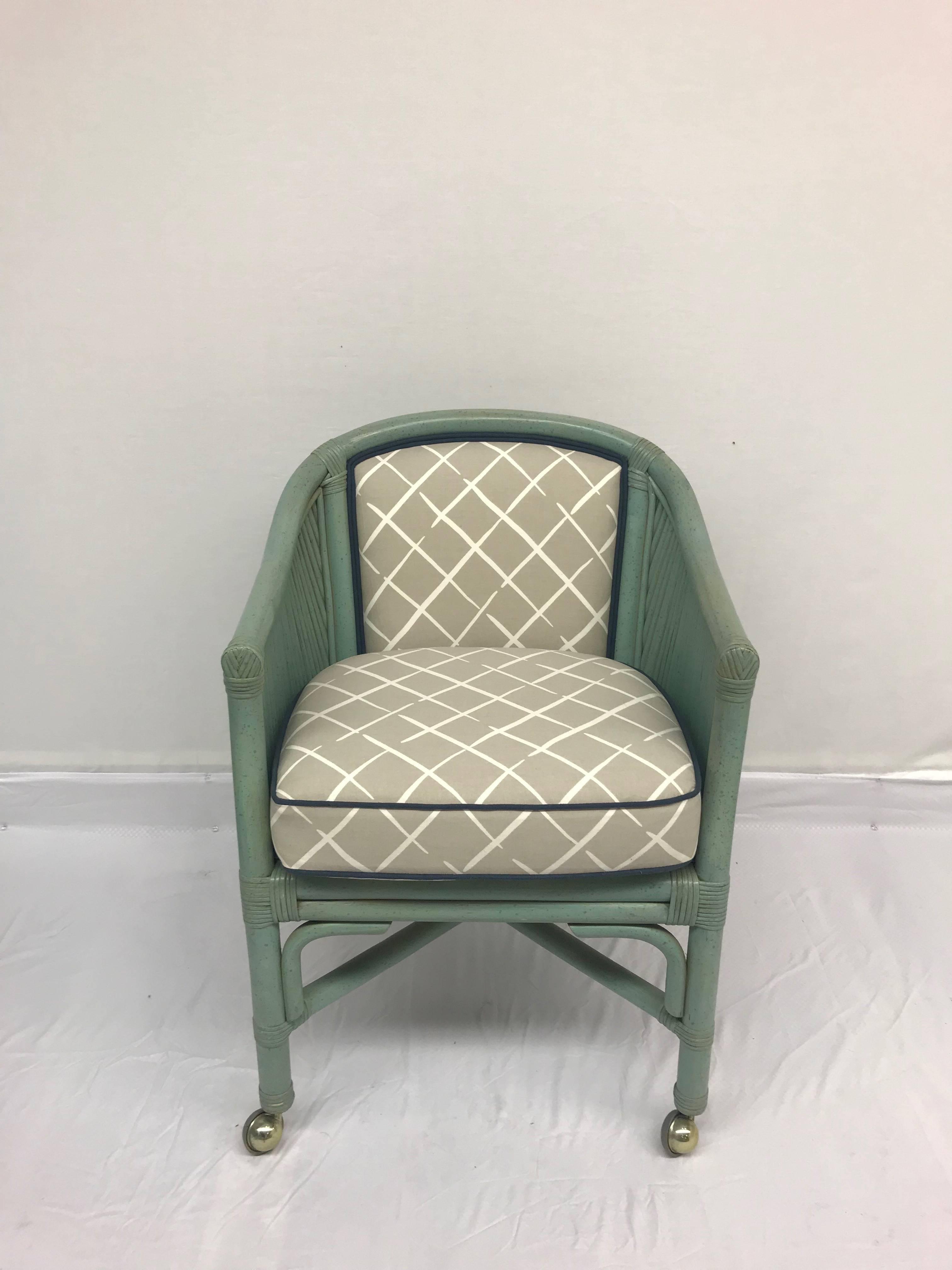 Four fabulous vintage seafoam-blue rattan chairs atop metal casters, newly upholstered in our shop for Robert Allen @Home Cove End fabric the Oyster color way with deep blue welting. Perfect for a game table. Chair finish is original. Upholstery is