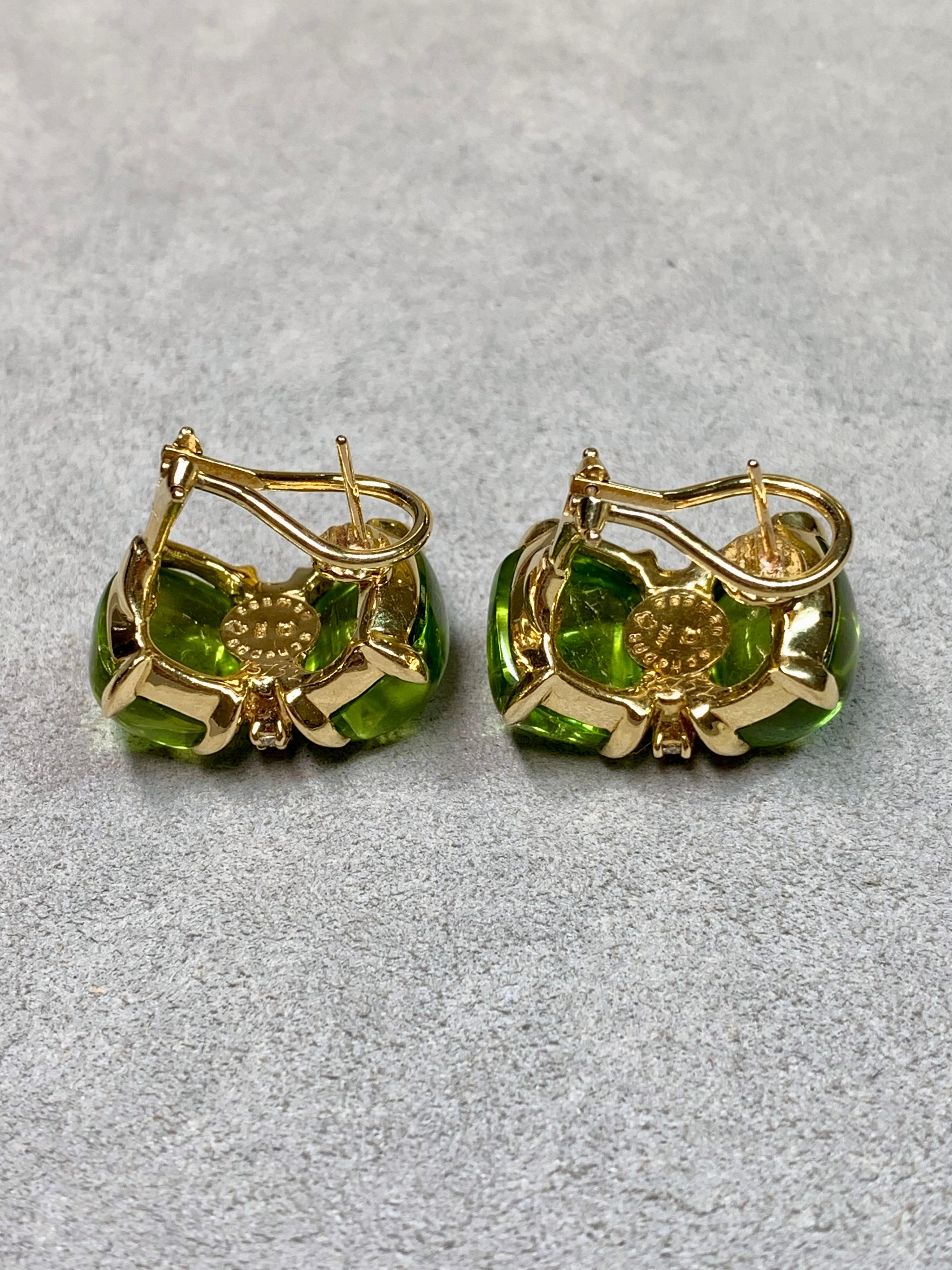 
A striking and exceptionally well-made pair of bold huggie earrings by renowned American jeweler Seaman Schepps, crafted in rich 18K yellow gold. Each earring features two lush, highly domed cabochon peridots exhibiting vivid apple-green coloration