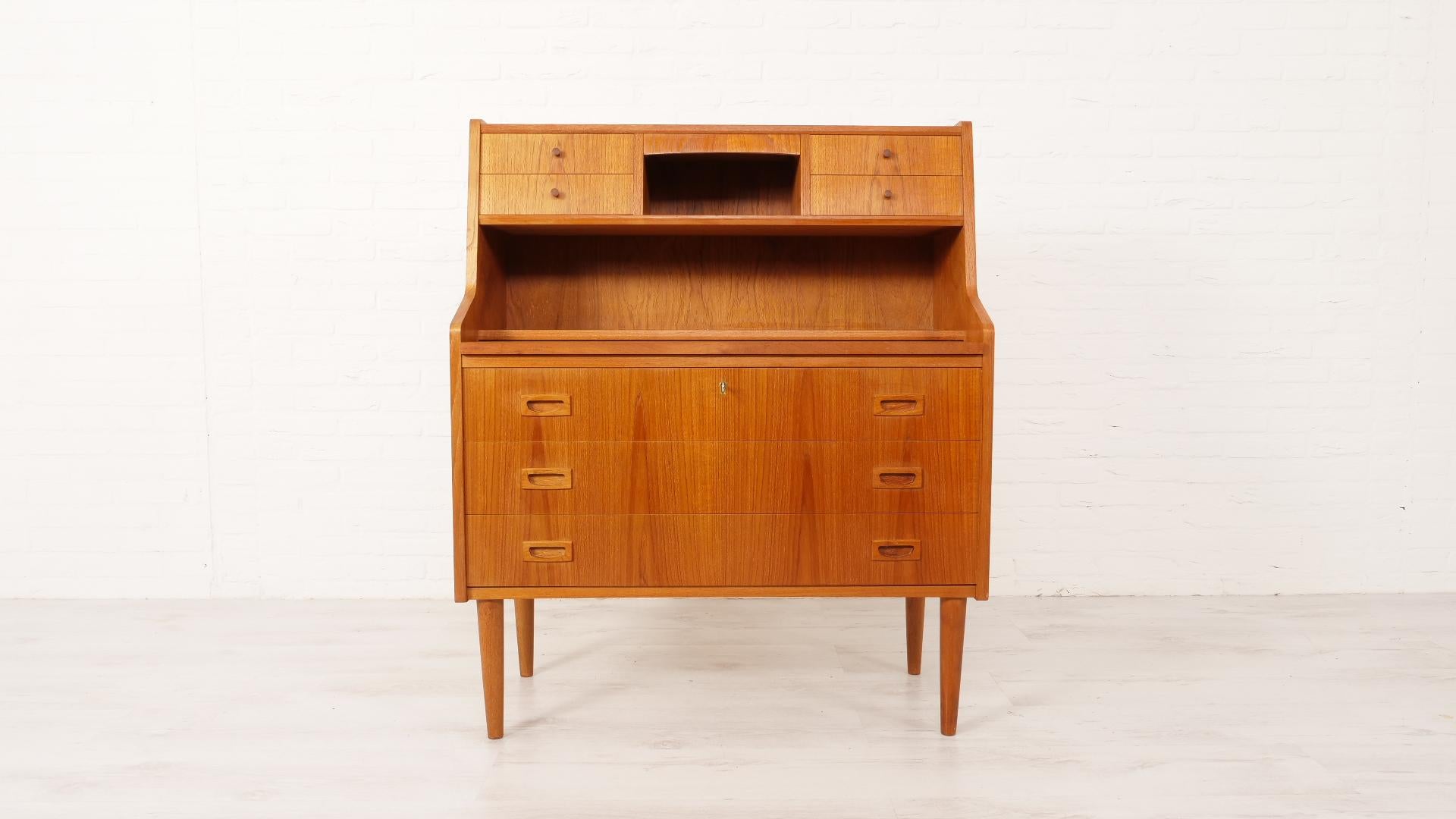 Beautiful secretary from the 1960s. The vintage teak cabinet has a pull-out desk, ideal! In addition, the cupboard has 4 drawers at the top and a mirror. So the cupboard can also be used as a vintage dressing table. At the bottom you will find 3