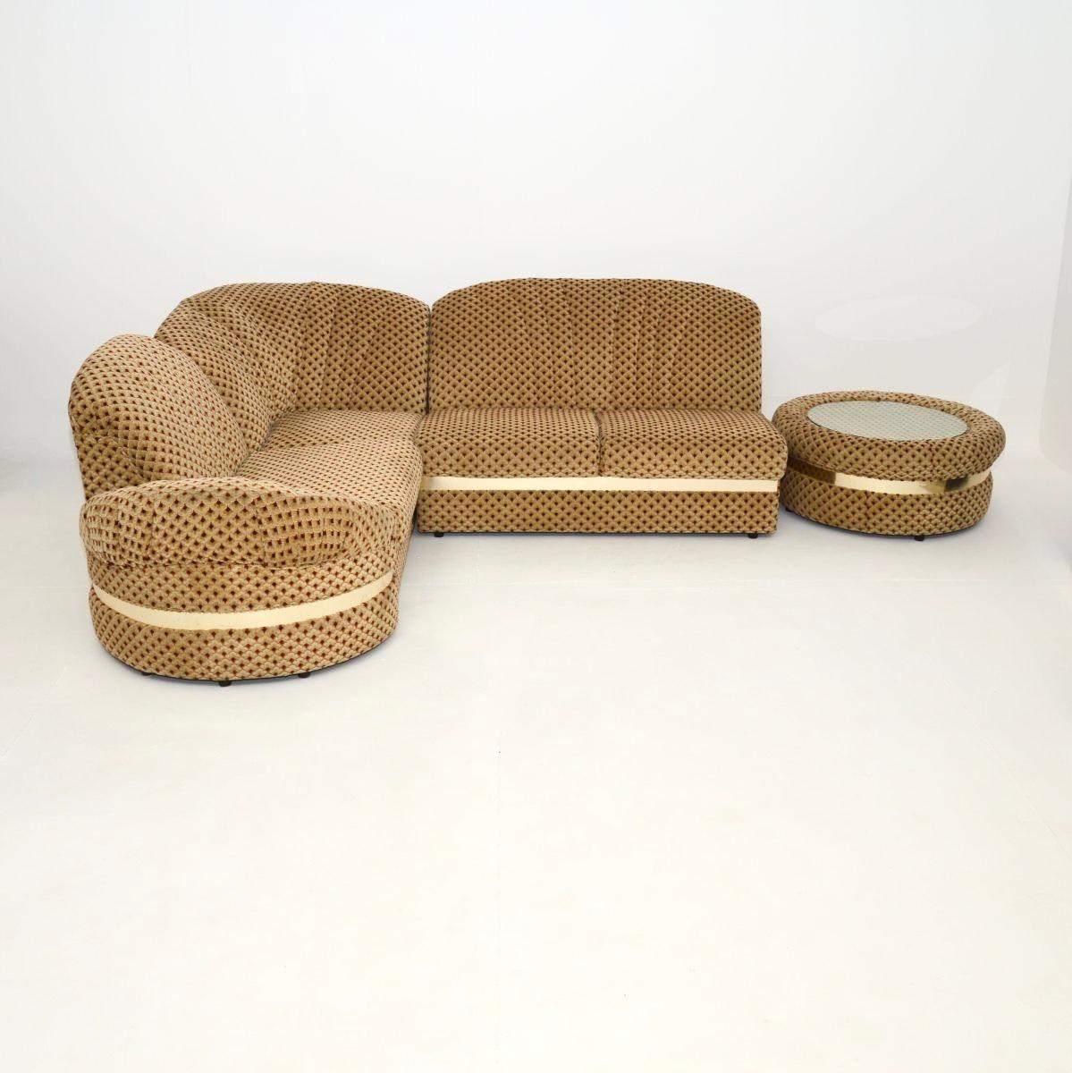 Un canapé d'angle sectionnel vintage élégant et extrêmement confortable avec table. Il a été fabriqué en Angleterre, il date des années 1970.

Il est d'excellente qualité, il a un design très utile et pratique. Le tissu d'origine est d'une qualité