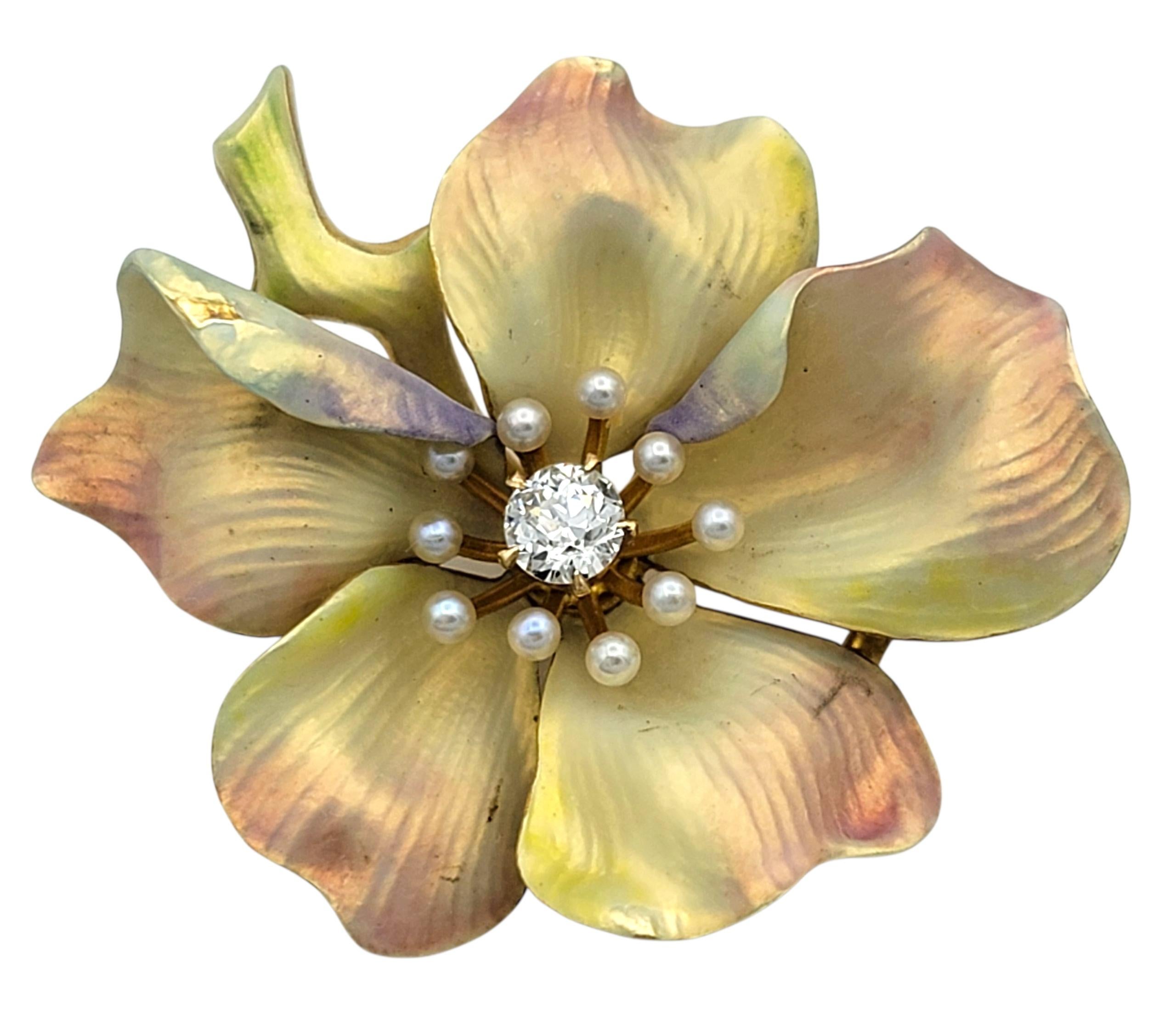 This charming vintage flower pin is crafted in 14 karat yellow gold with delicate enameled petals in warm shades of yellow and peach. At the center blooms a brilliant diamond, surrounded by a circle of petite cultured seed pearls that lend a soft,