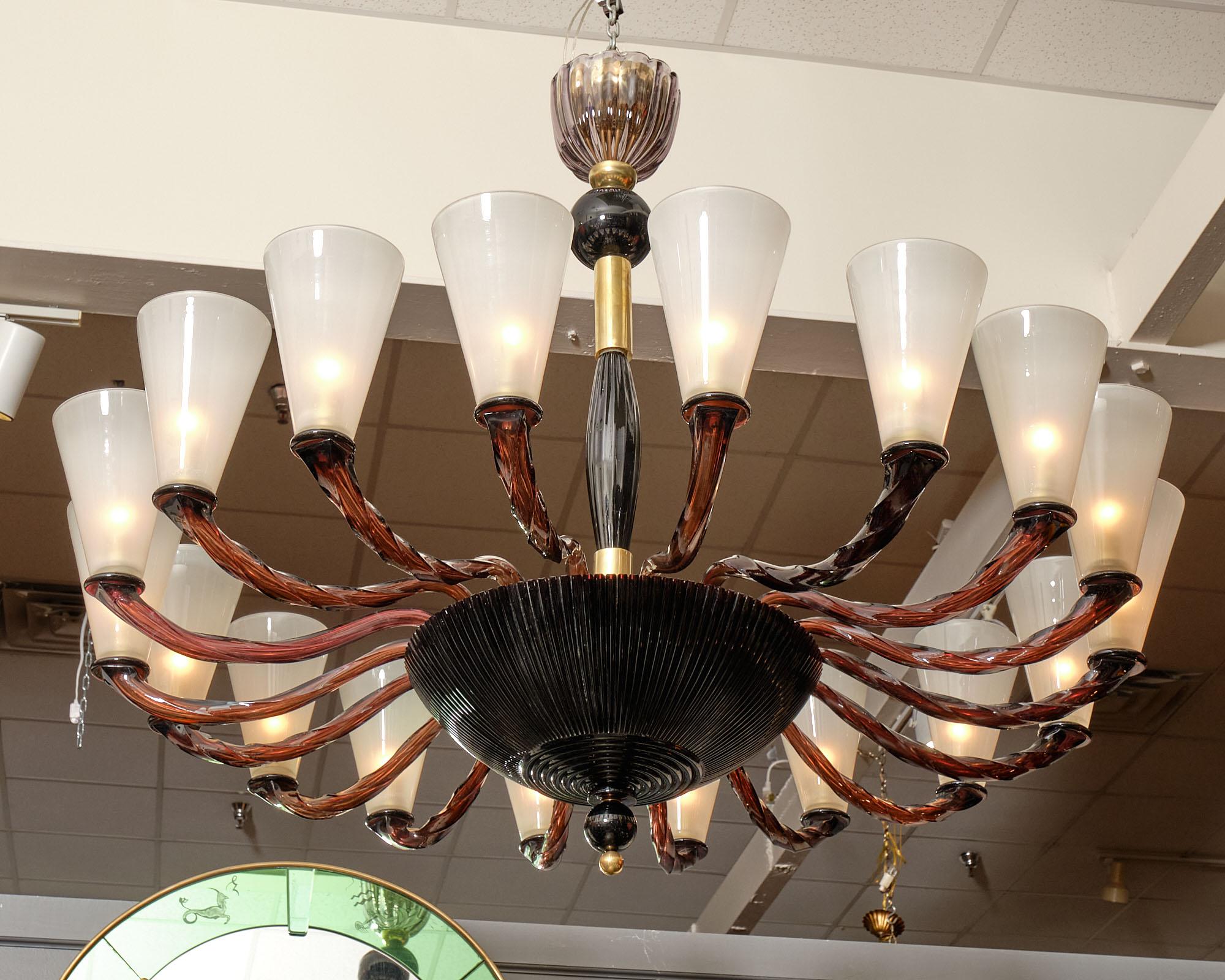Vintage Italian chandelier attributed to the iconic Seguso factory on the island of Murano. This piece has 18 “braided” branches crafted in a dark amethyst Murano glass. These branches support 18 frosted cone shaped Murano shades. This chandelier is