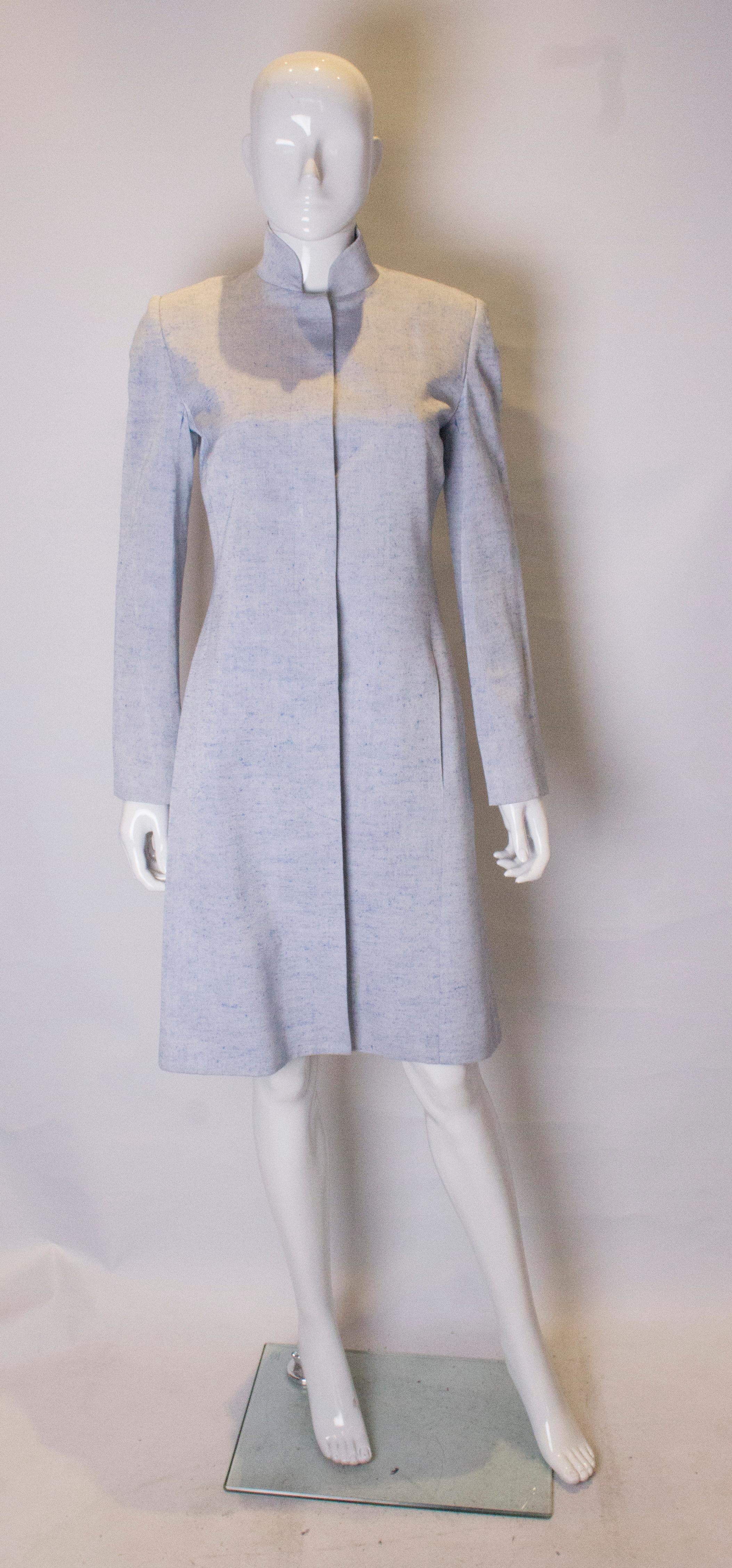A great coat for Spring by Selina Blow. In a sky blue fabric , the coat has a nehru collar, hidden button fastenings and a pocket on either side It is fully lined.