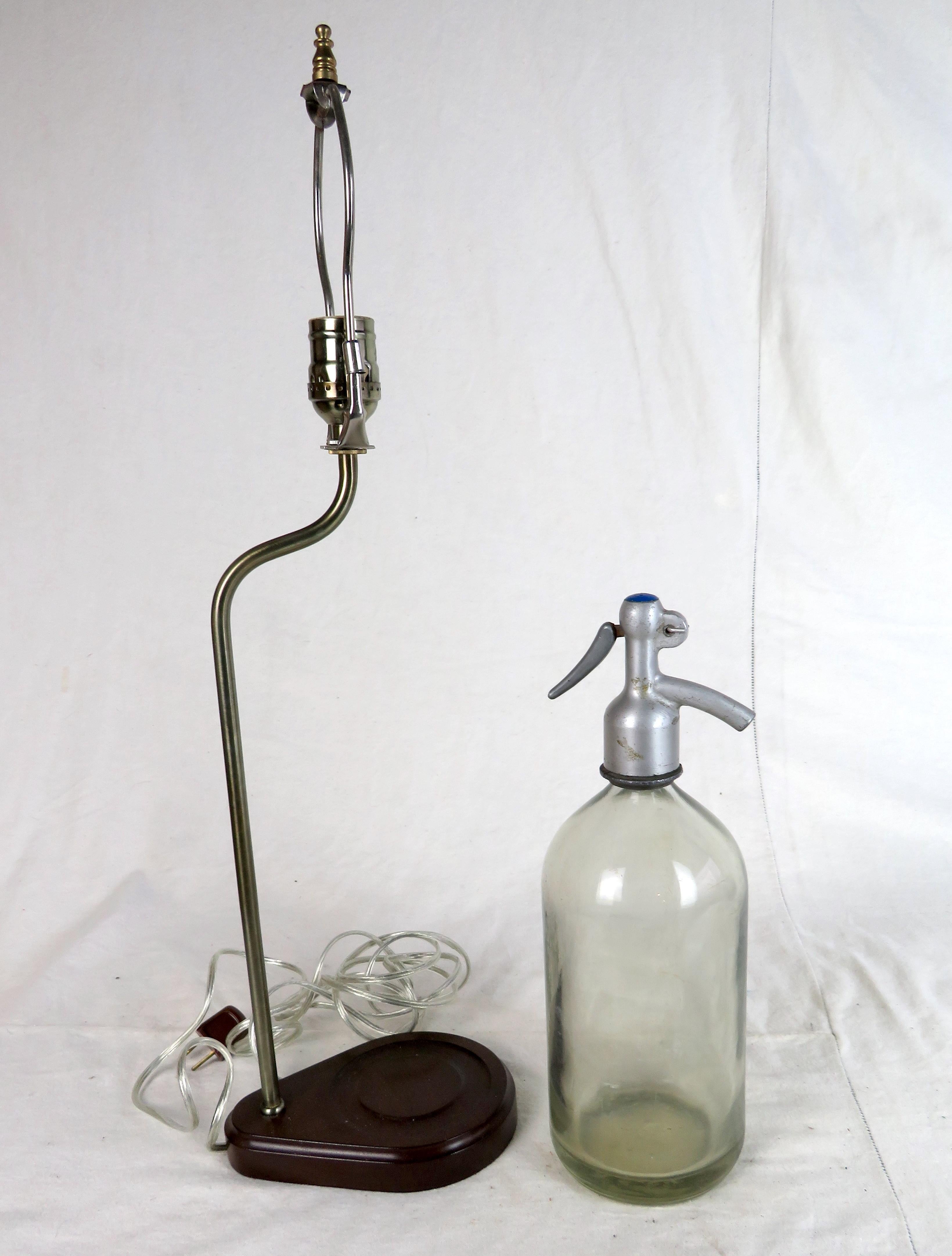 Vintage green glass seltzer bottle converted to lamp. Sits on custom wooden base mounted with lamp arm and accompanying shade. Great addition to any home bar.