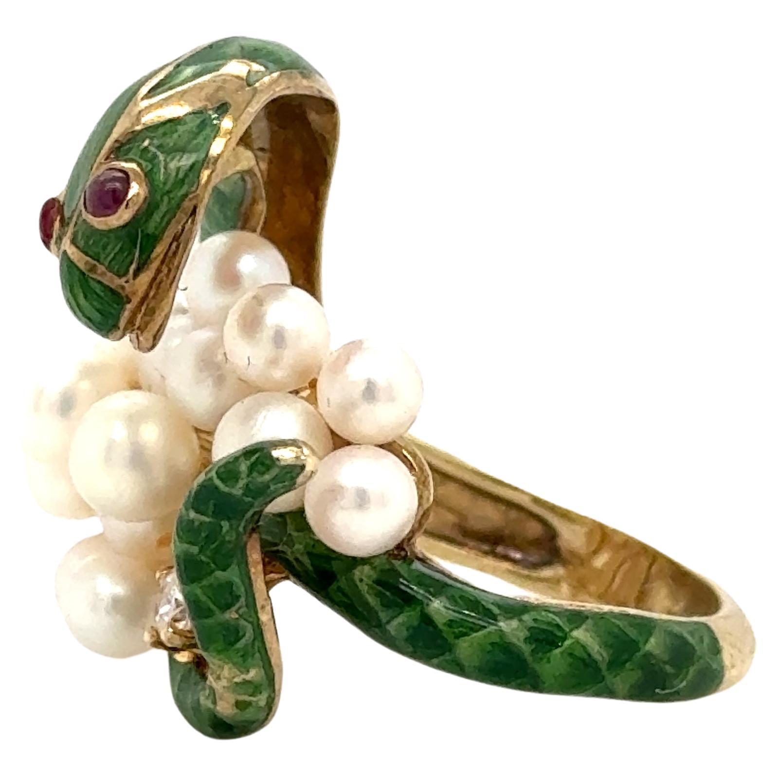 Precioso anillo elaborado en oro amarillo de 18 quilates. El anillo tiene forma de serpiente y está decorado con un vibrante esmalte verde con diamantes, rubíes y perlas engastados. 
El diseño de serpiente envuelve maravillosamente tu dedo cuando lo