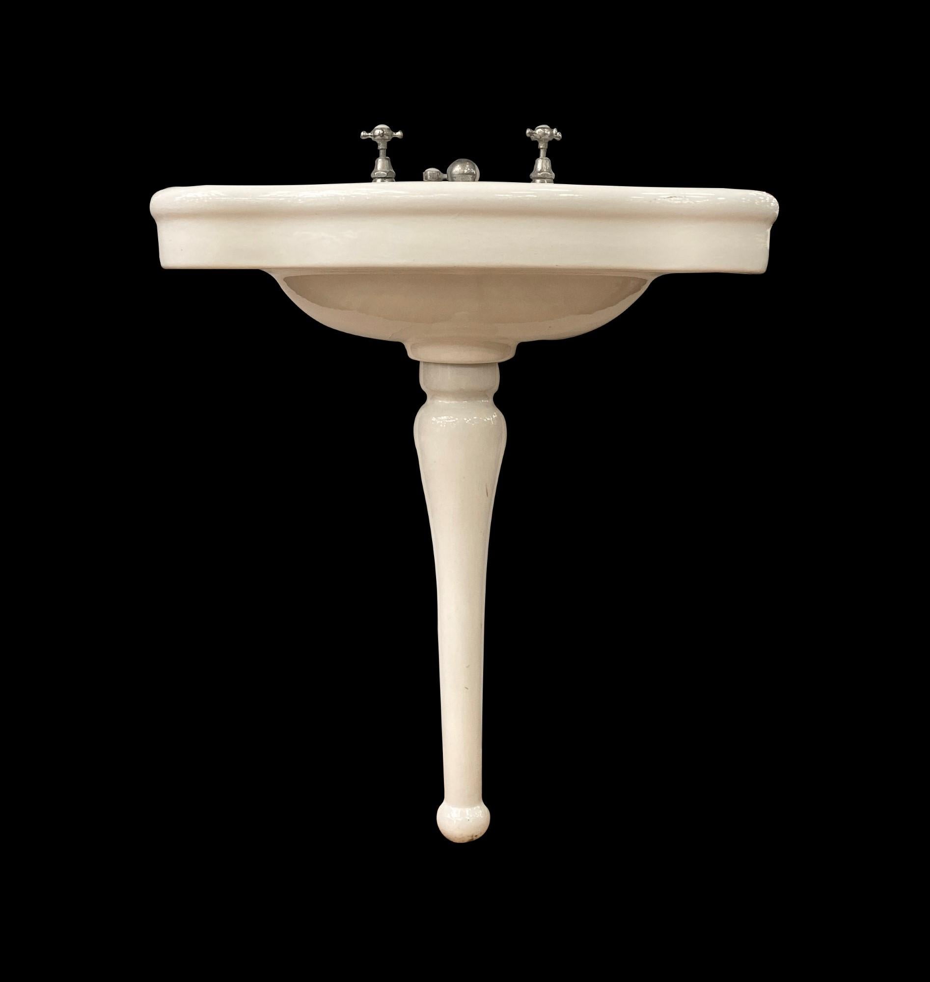 Early 20th century white ceramic sink with a serpentine front and original hardware. Made by Porcher, Paris. Drain hardware is missing. This can be seen at our 333 West 52nd St location in the Theater District West of Manhattan.