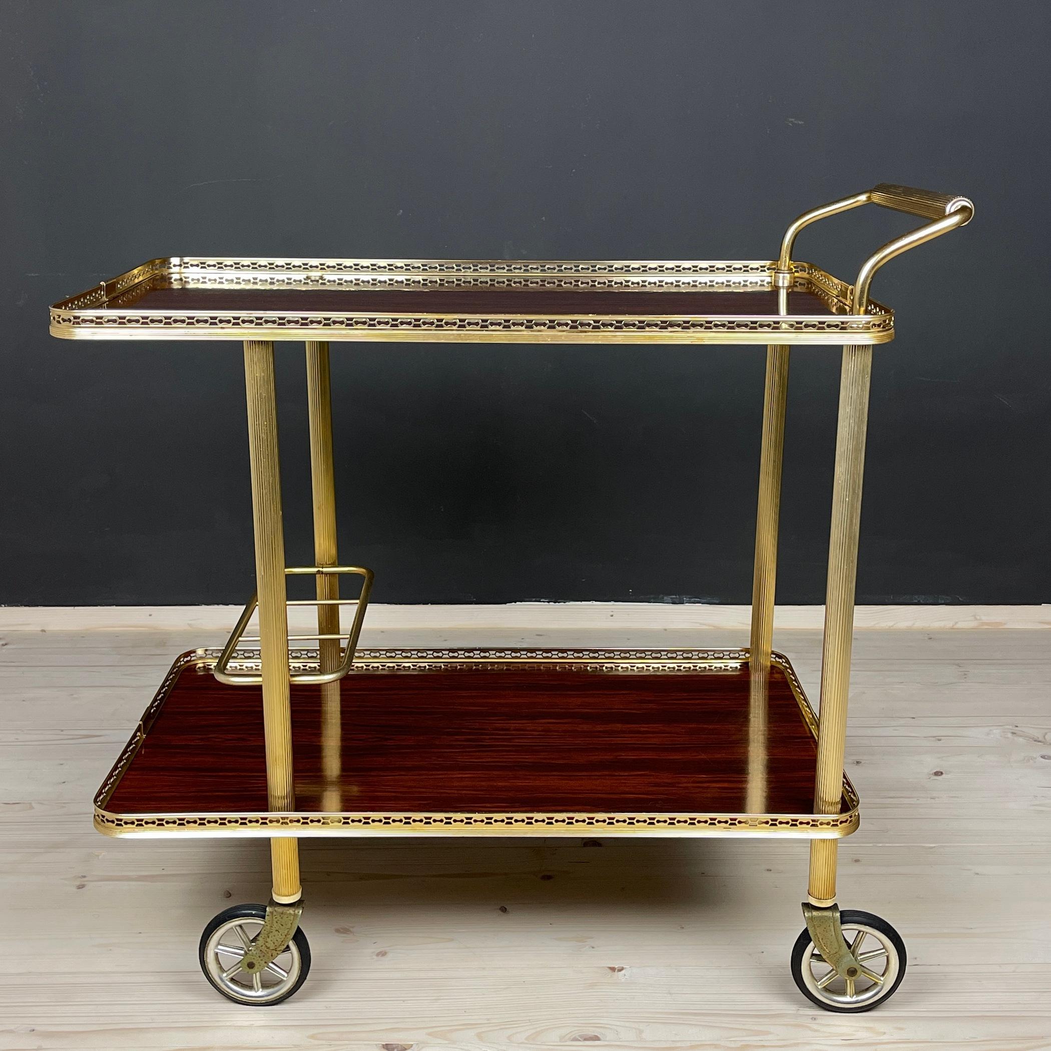 Vintage Italian trolley on 4 wheels. This cocktail bar drinks cart was made in Italy in a 1970s Hollywood Regency style. It has surrounded by a filigree brass railing around an oval tray. Perfect for drinks, tea, coffee. Very good vintage condition