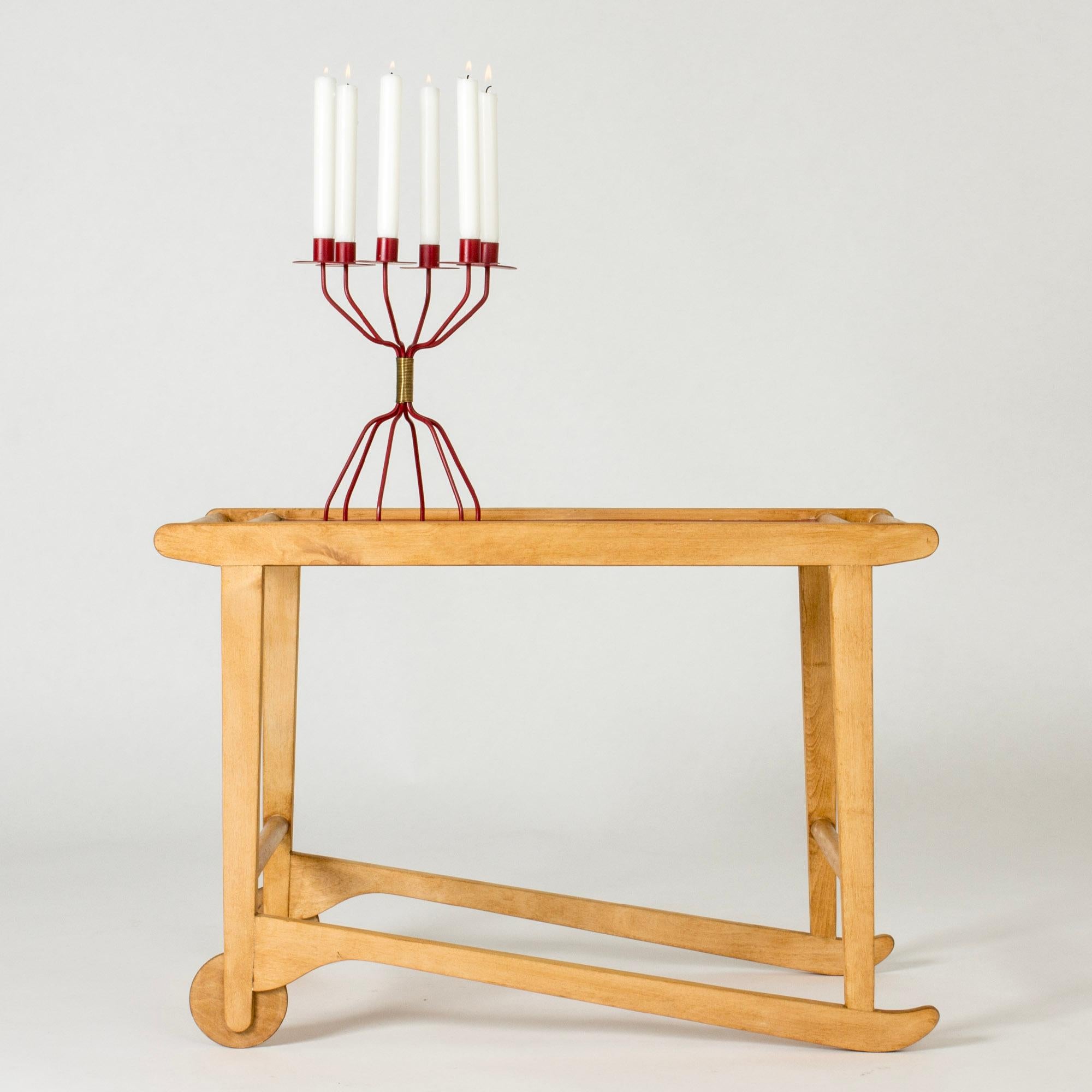 Cool serving trolley by Ilmari Tapiovaara, made from birch. Small wheels, sled legs. Table top lacquered lipstick red.