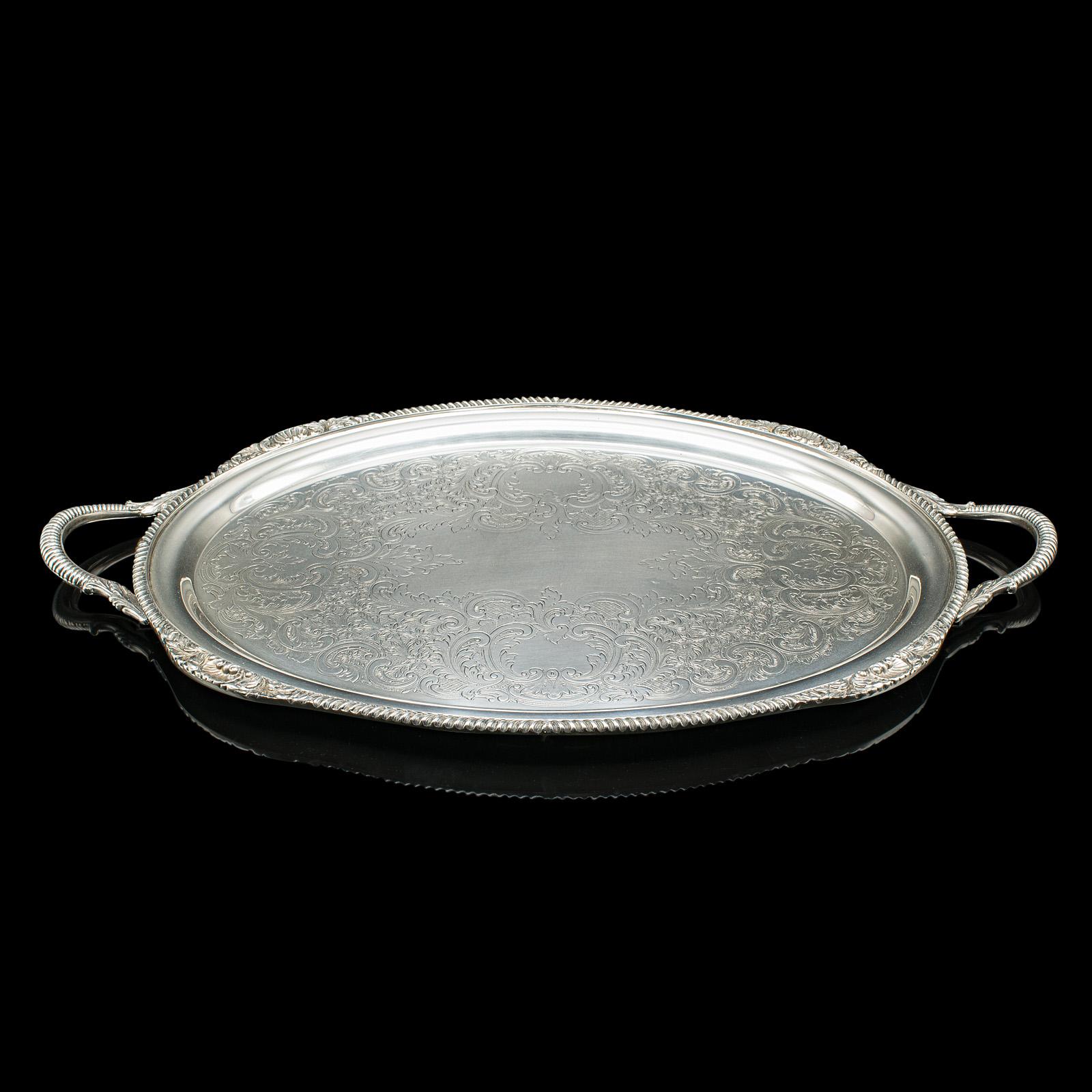 Il s'agit d'un grand plateau de service vintage, magnifiquement réalisé en métal argenté par la société américaine Sheffield Silver Co., datant du début du 20e siècle, vers 1930. Ce superbe plateau présente des proportions élégantes, des détails