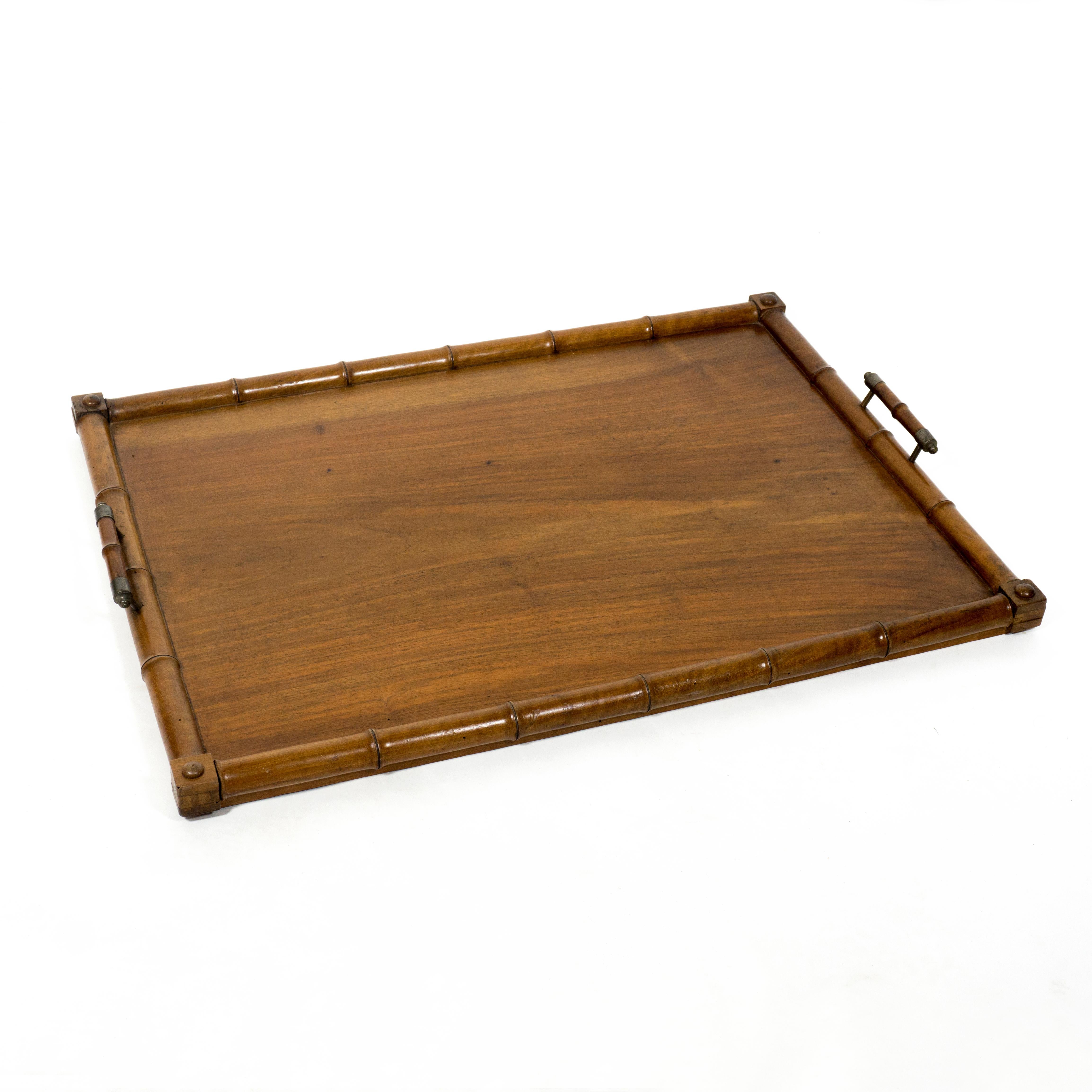 Large wooden serving tray. This wonderful piece was made in Italy at the beginning of the 20th century. 
This simple yet very stylish serving tray is finished with a wooden faux bamboo frame and both handles have lovely metal applicatins.
The Tray