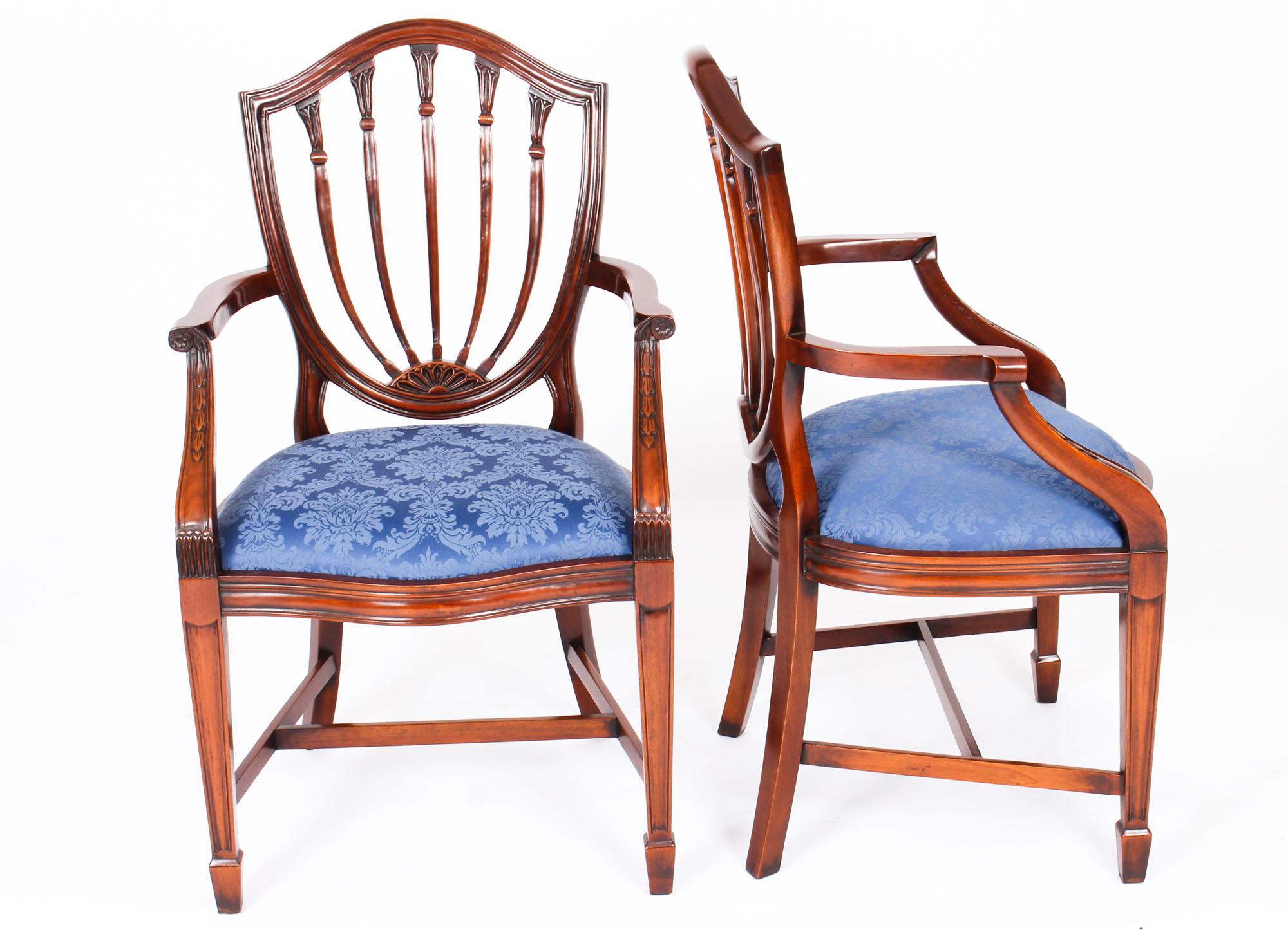 An absolutely fantastic Vintage set of eighteen Hepplewhite Revival dining chairs.

Beautifully hand crafted from solid mahogany the set comprises sixteen side chairs and two armchairs, all of which feature an attractive shieldback design and 'drop
