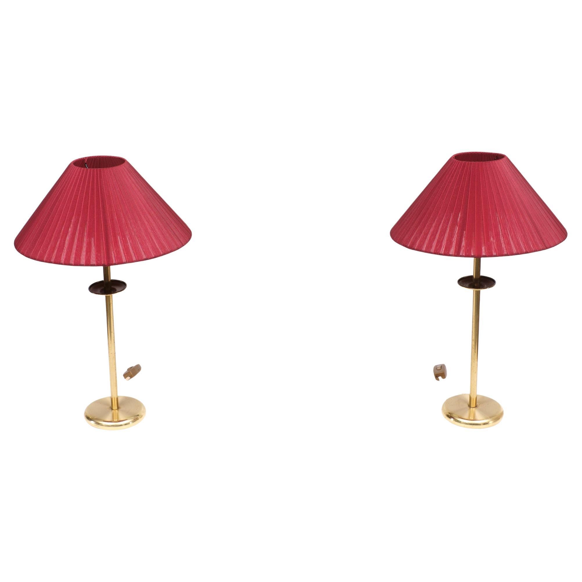 Two very nice brass table lamps comes with new red shades. Switch on 
the cord. Sleek design. Signed ATD.