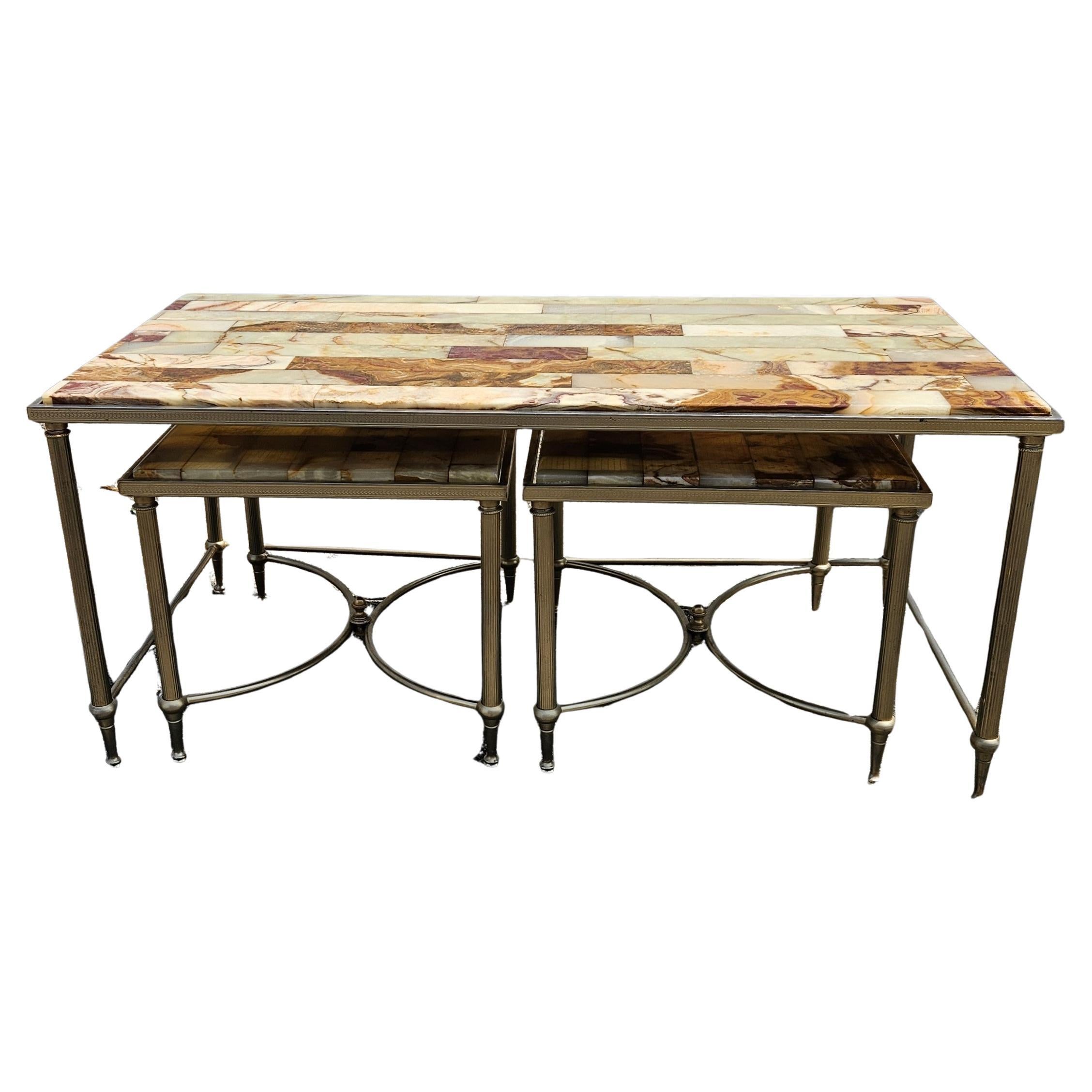 Discover the Elegance of the 70s with this rare French Onyx Table Set.
Featuring a Onyx Marble Coffee Table and two Side Tables in Maison Jansen Style.
The 3 Tabletops display a stunning mix of jade green, mother of pearl, orange and brown tones