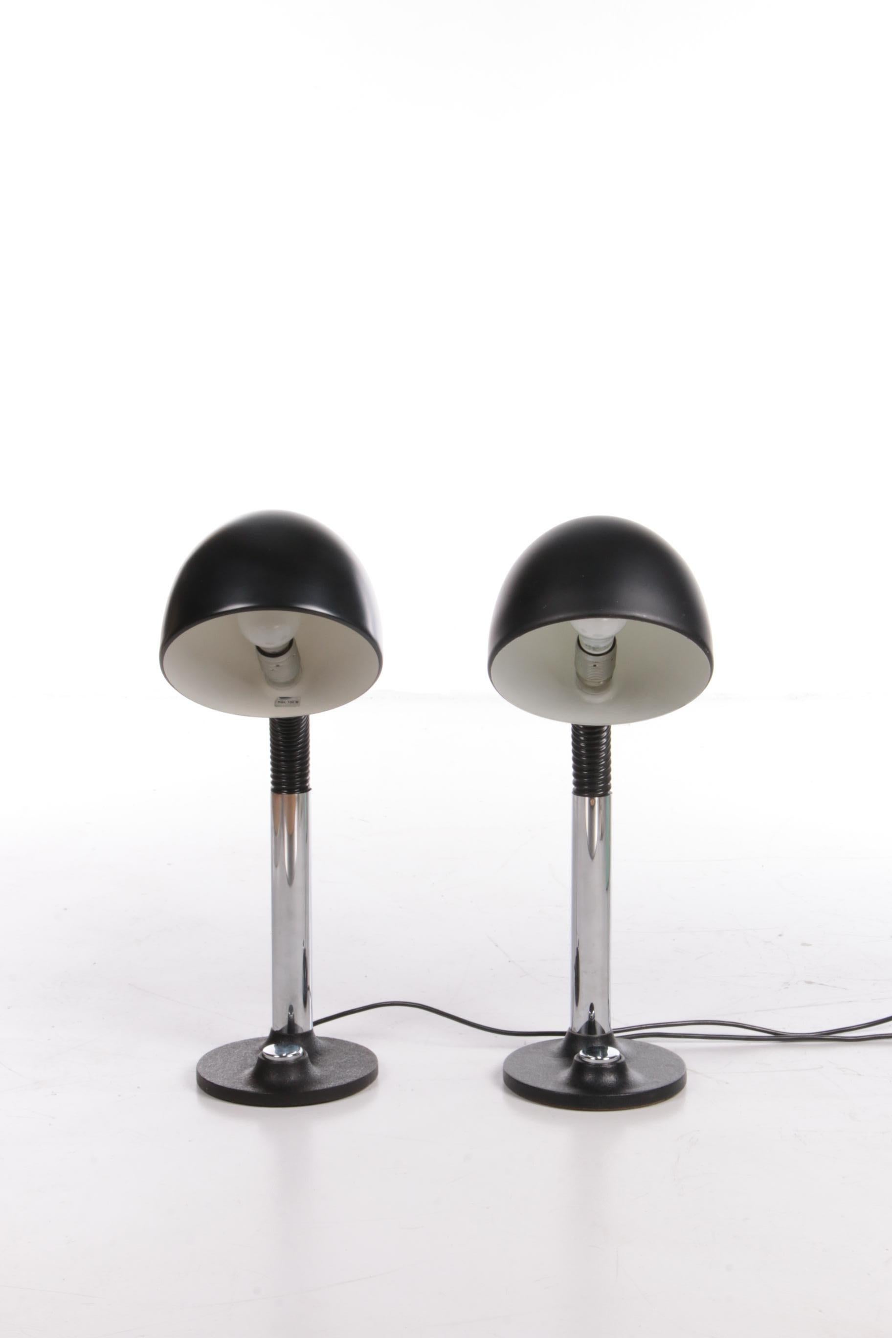 A set of two large desk lamps (model 7404), made in the 1970s by Hillebrand, Germany. Both lamps are in very good vintage condition.

This model has a black round cast iron base with a built-in large chrome switch. The lamps have a metal gooseneck