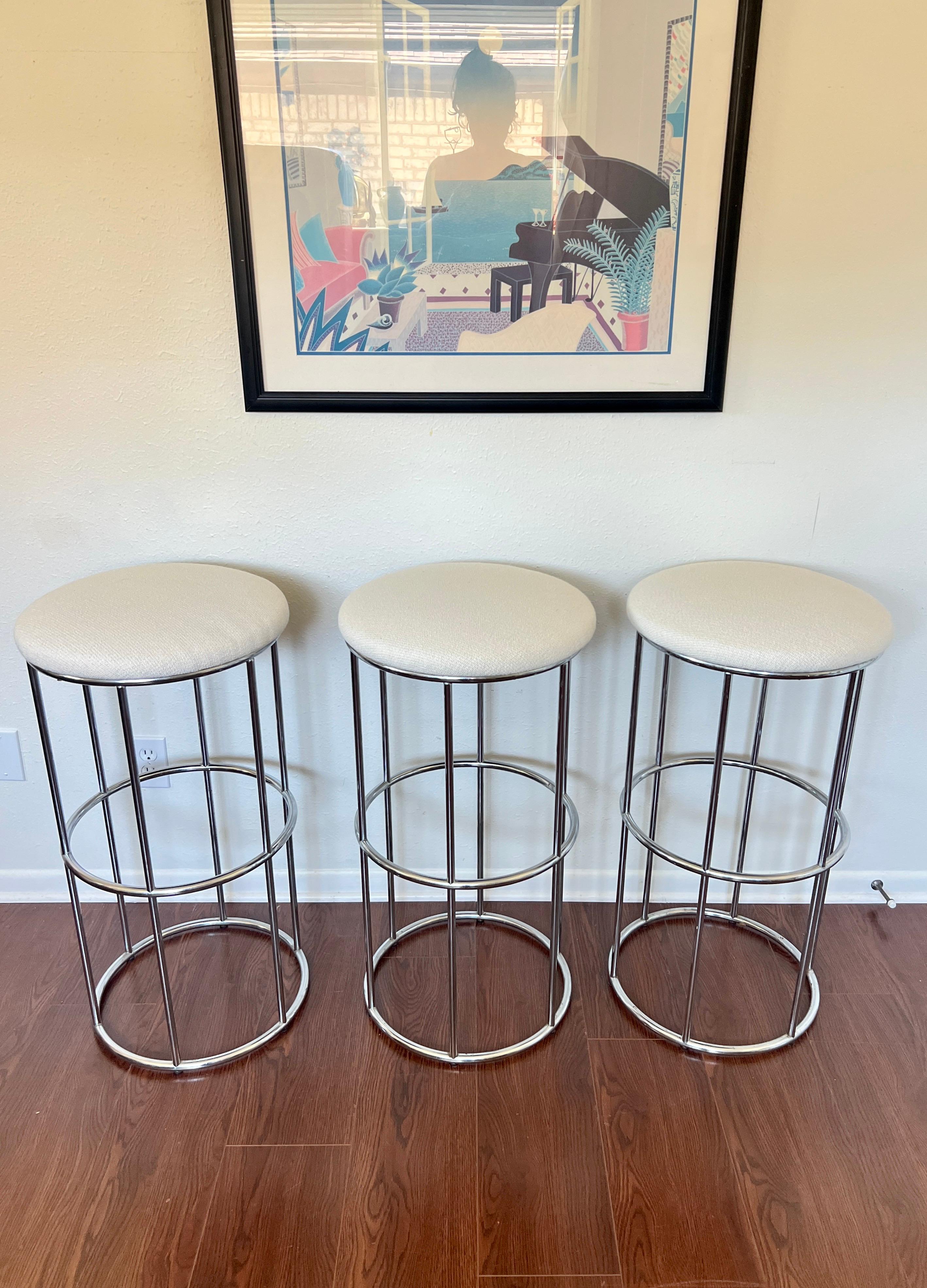 Vintage set of 3 chrome barstools newly reupholstered in an ivory boucle fabric, circa 1970s. Attributed to Milo Baughman. This minimalist design goes with any modern interior. Overall in excellent condition.

30” H x 16” W