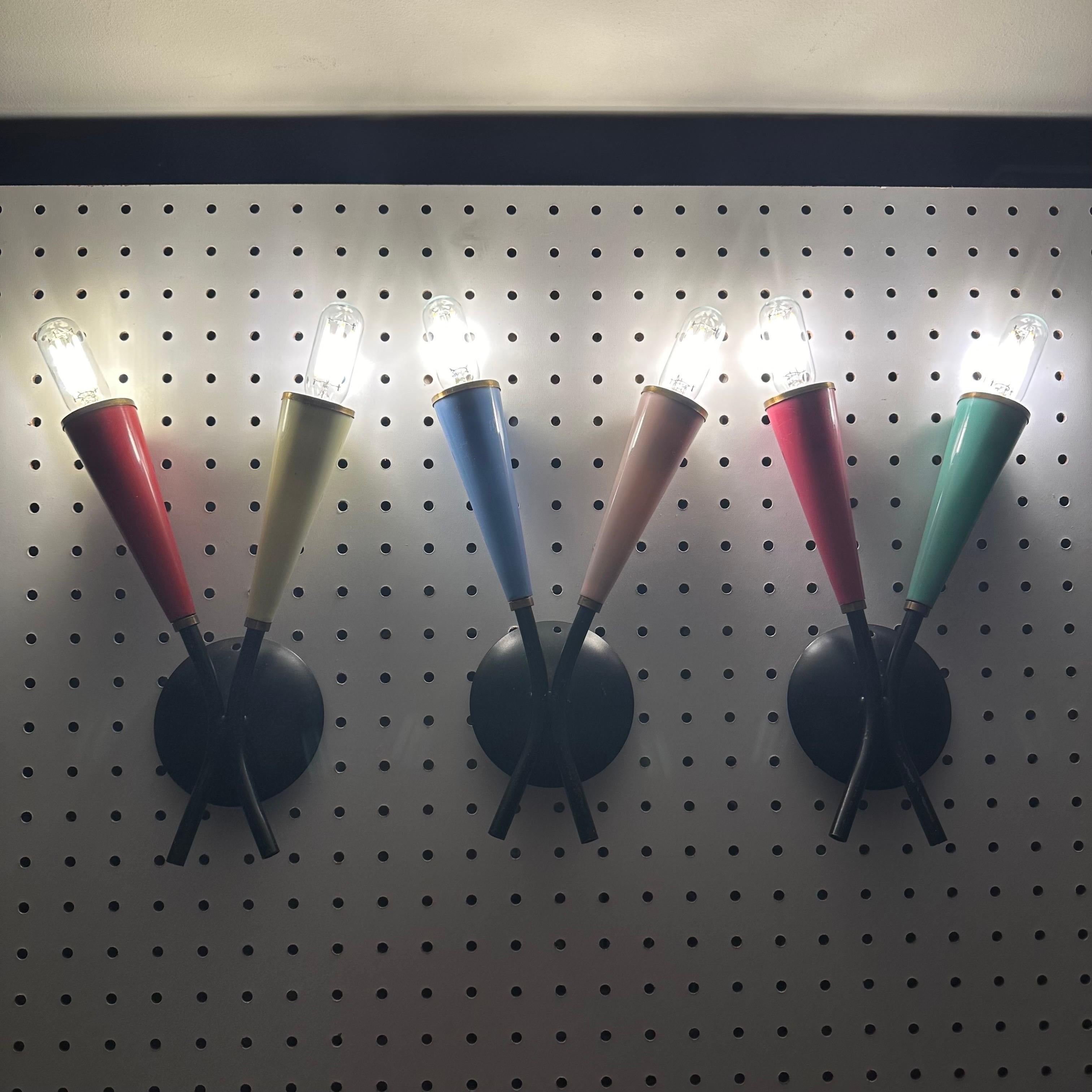 Set di 3 applique italiane vintage. Ogni applique è composta da 2 bracci neri e da una piastra posteriore rotonda nera che conduce a un cono di colore diverso, fissato con una ferramenta in ottone patinato. Ogni cono è di plastica di colore diverso.
