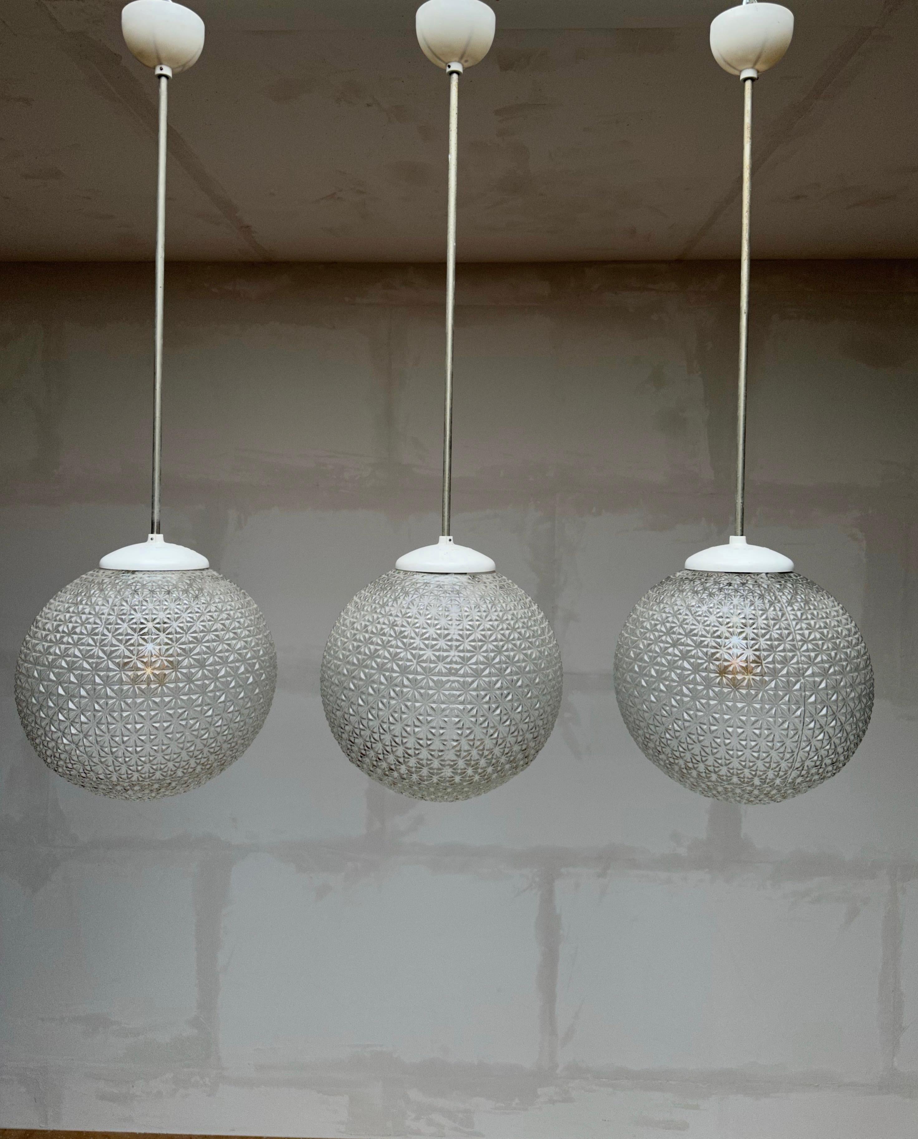 Group of three identical and good size, globe design pendant lights.

If you are looking for a group of beautiful and truly timeless pendants for a hallway, a large table or otherwise then this set of three could be your perfect lighting solution.