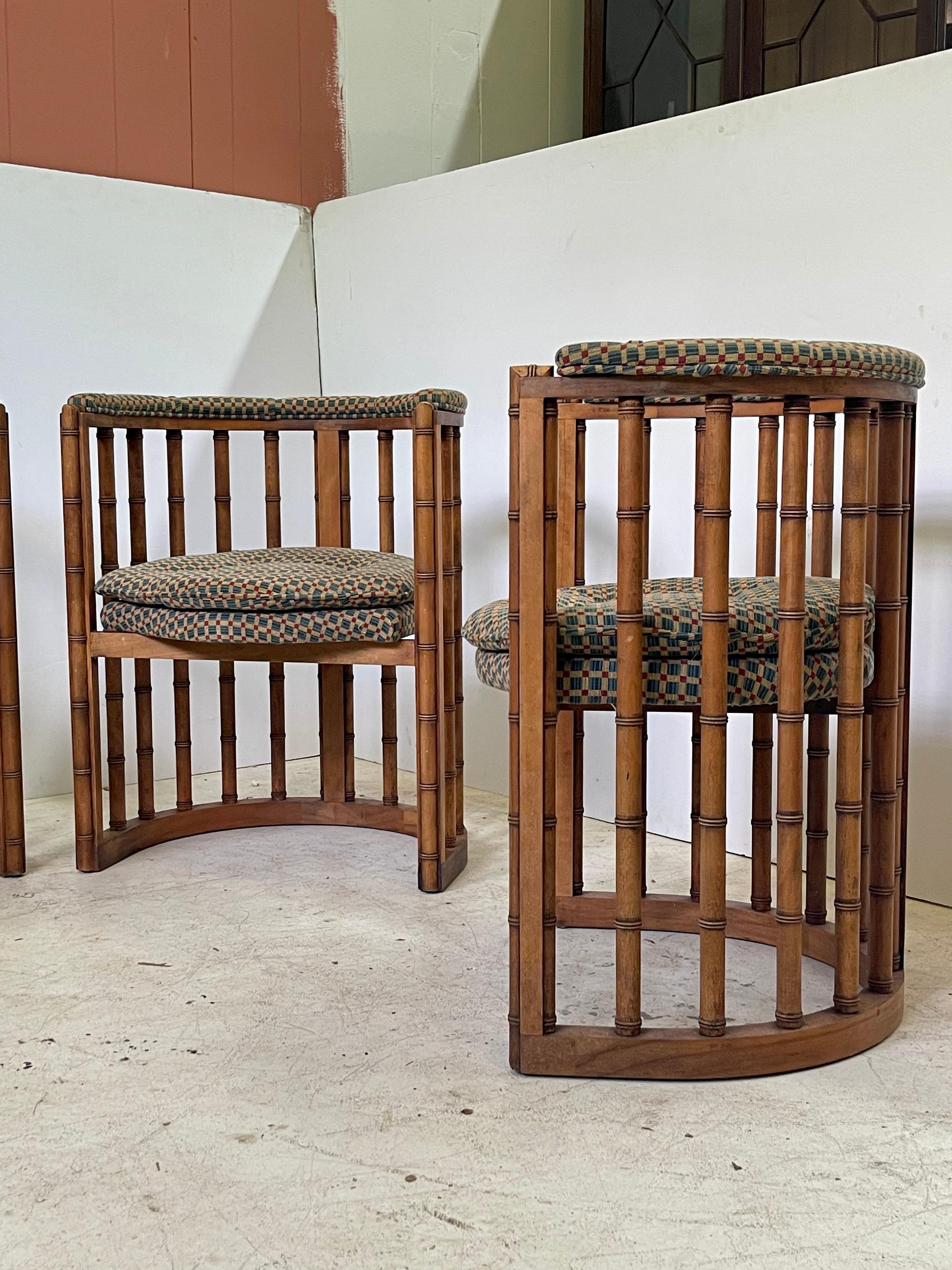 20th century set of four Hollywood Regency barrel back game chairs made of carved bamboo posts. The upper chair rail has a plush tufted and upholstered arm cushion. The seat has a comfortable tufted pillow-top cushion with a beautifully shaped