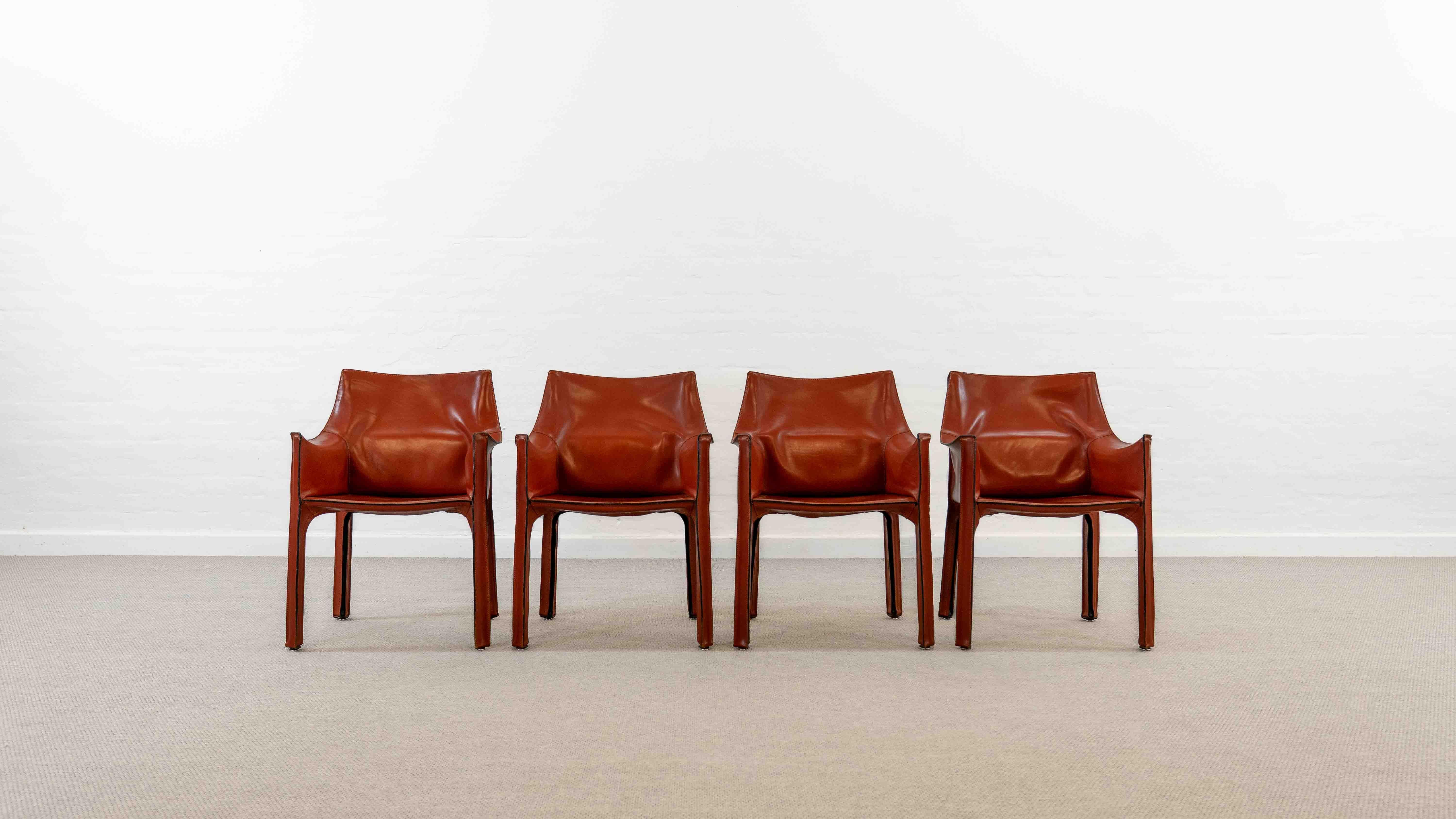 Set of 4 vintage armchairs, model 413 in red-brown leather, designed by Mario Bellini for Cassina. These chairs were originally acquired in the late 70s. All 4 chairs marked with Cassina sticker. Patina, signs of age and wear present. Abrasion on