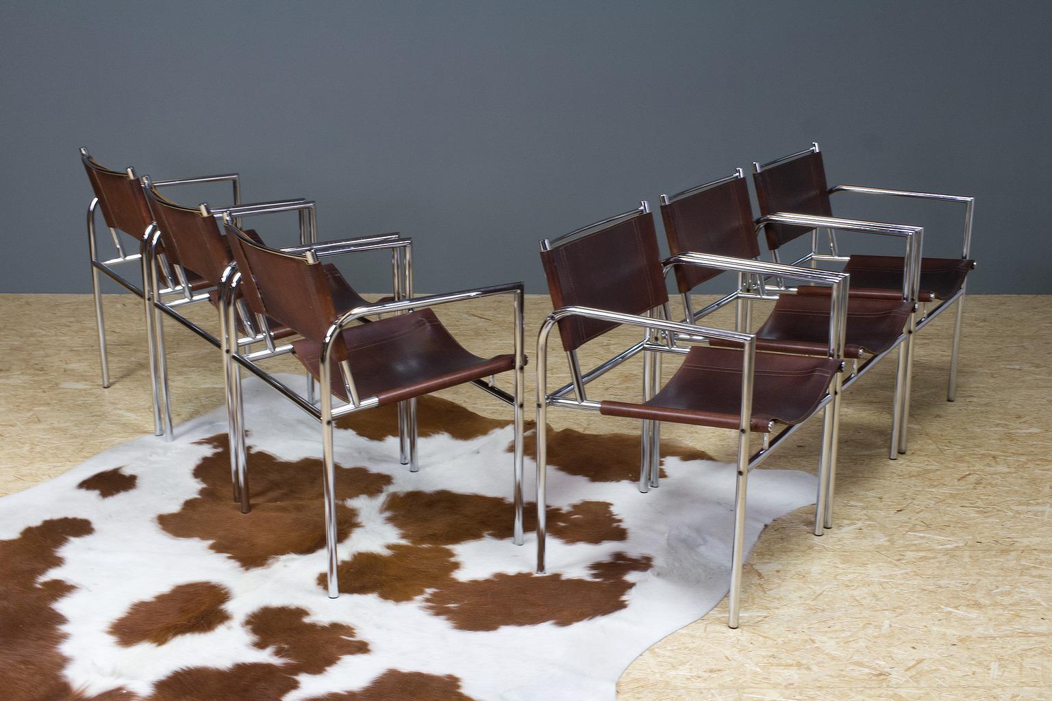 Great European vintage set of 6 dining room chairs in brown leather and chromed metal, tubular frame with armrests. 1960s design in manner of Charlotte Perriand or Martin Visser, origin unknown, no label present. The chairs are well detailed, and