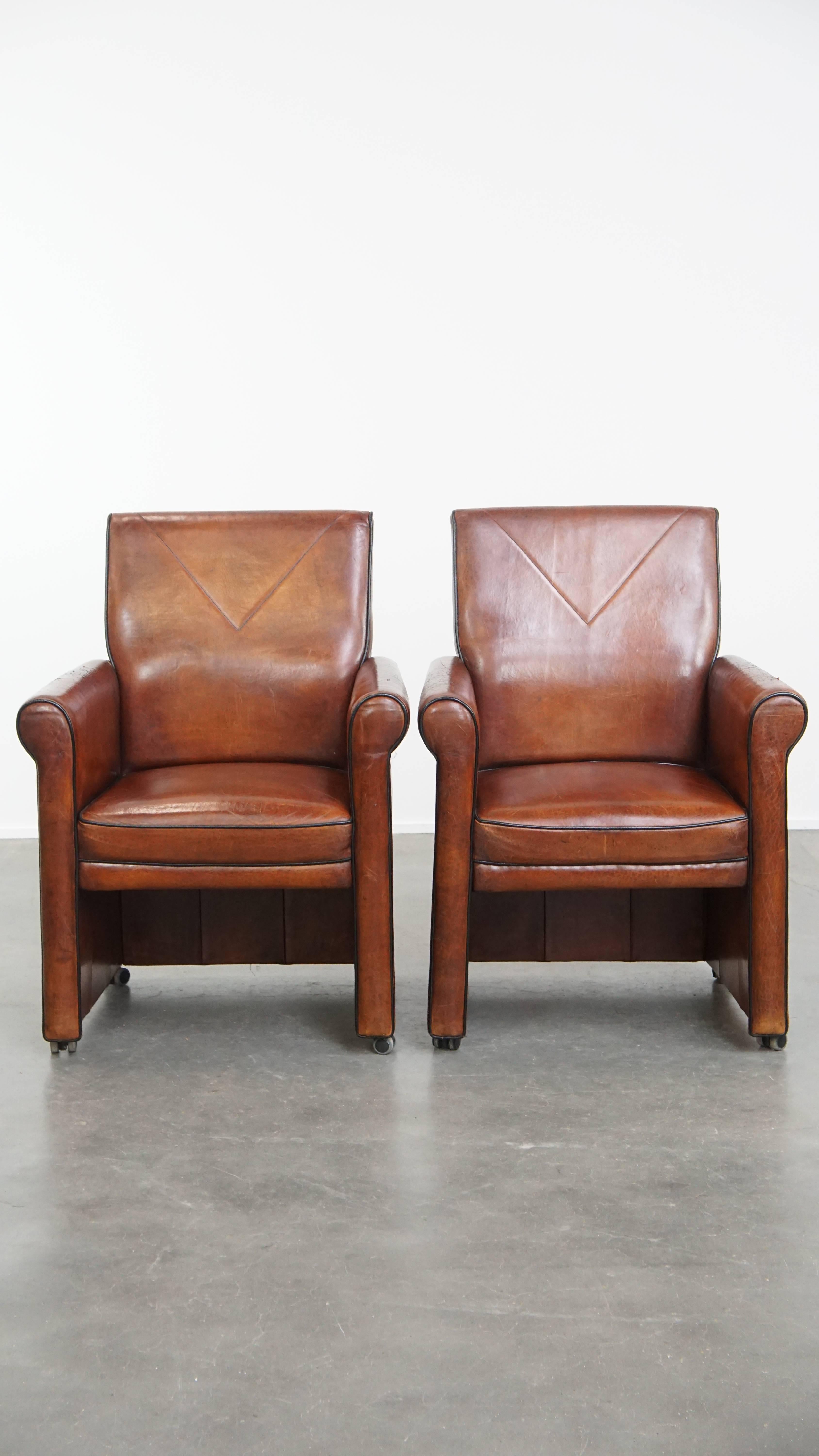 Offered here is this characterful vintage set of 6 sheep leather dining chairs with black piping and wheels. These charming and practical vintage dining chairs, made from sheep leather, have a timeless appeal that allows them to blend effortlessly
