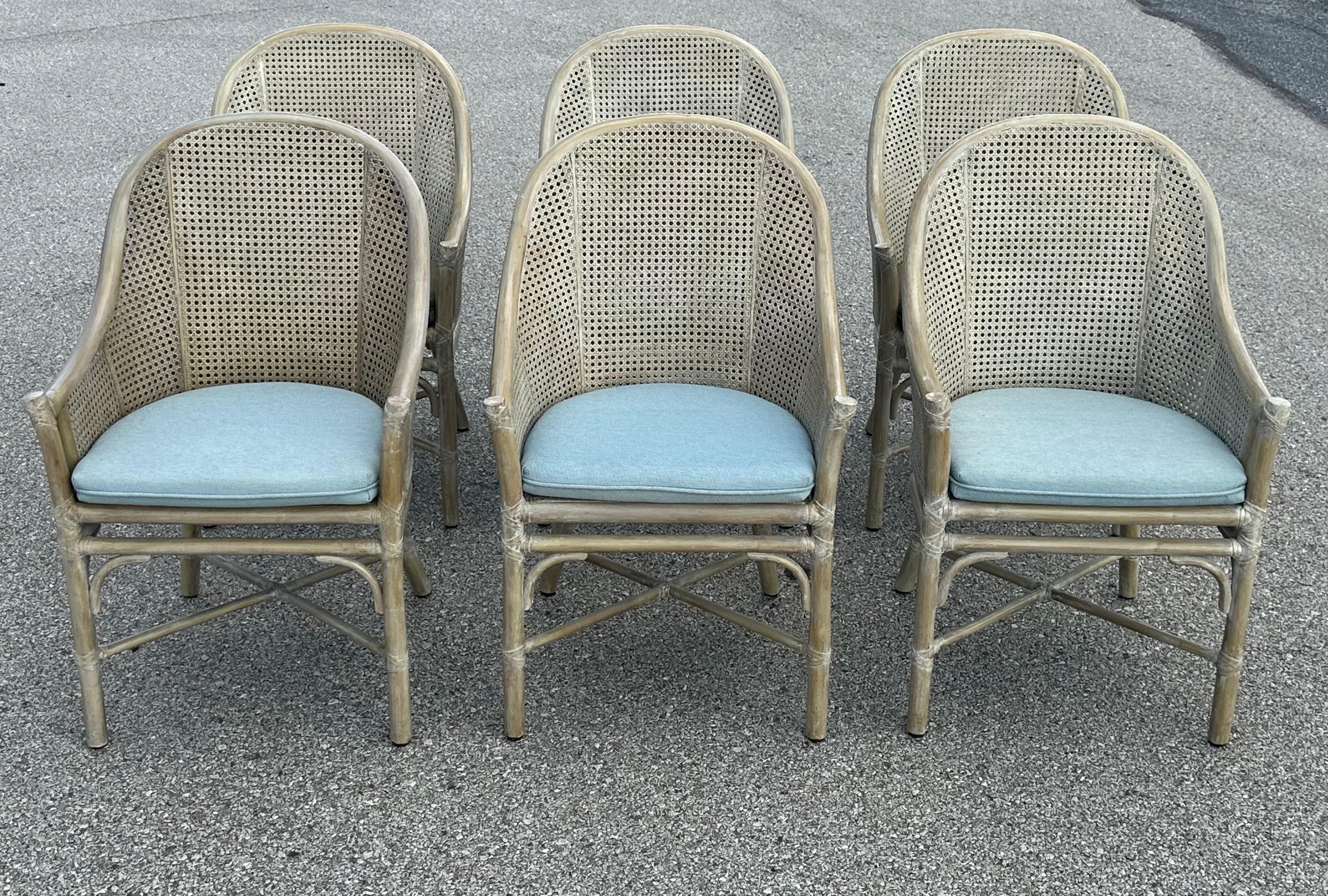 Nice late 1970s vintage set of 6, California casual designed McGuire San Francisco dining chairs made of bent rattan and caning with loose upholstered seat. Feature a barrel back, X stretcher and McGuire innovation of double caning on the back and