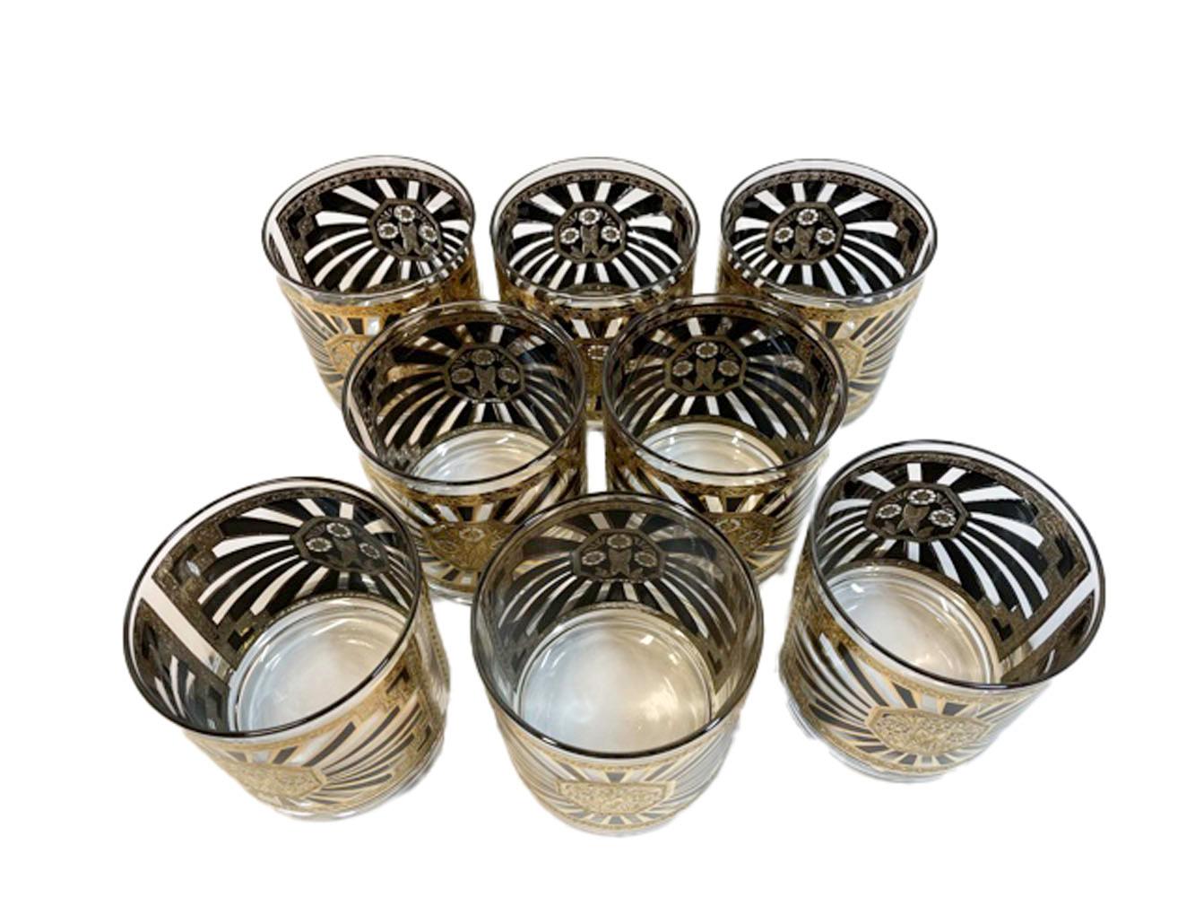 Mid-Century Modern, set of 8 rocks glasses designed by Georges Briard in the Art Deco pattern of classic motifs executed in black enamel and 22k gold with platinum details.