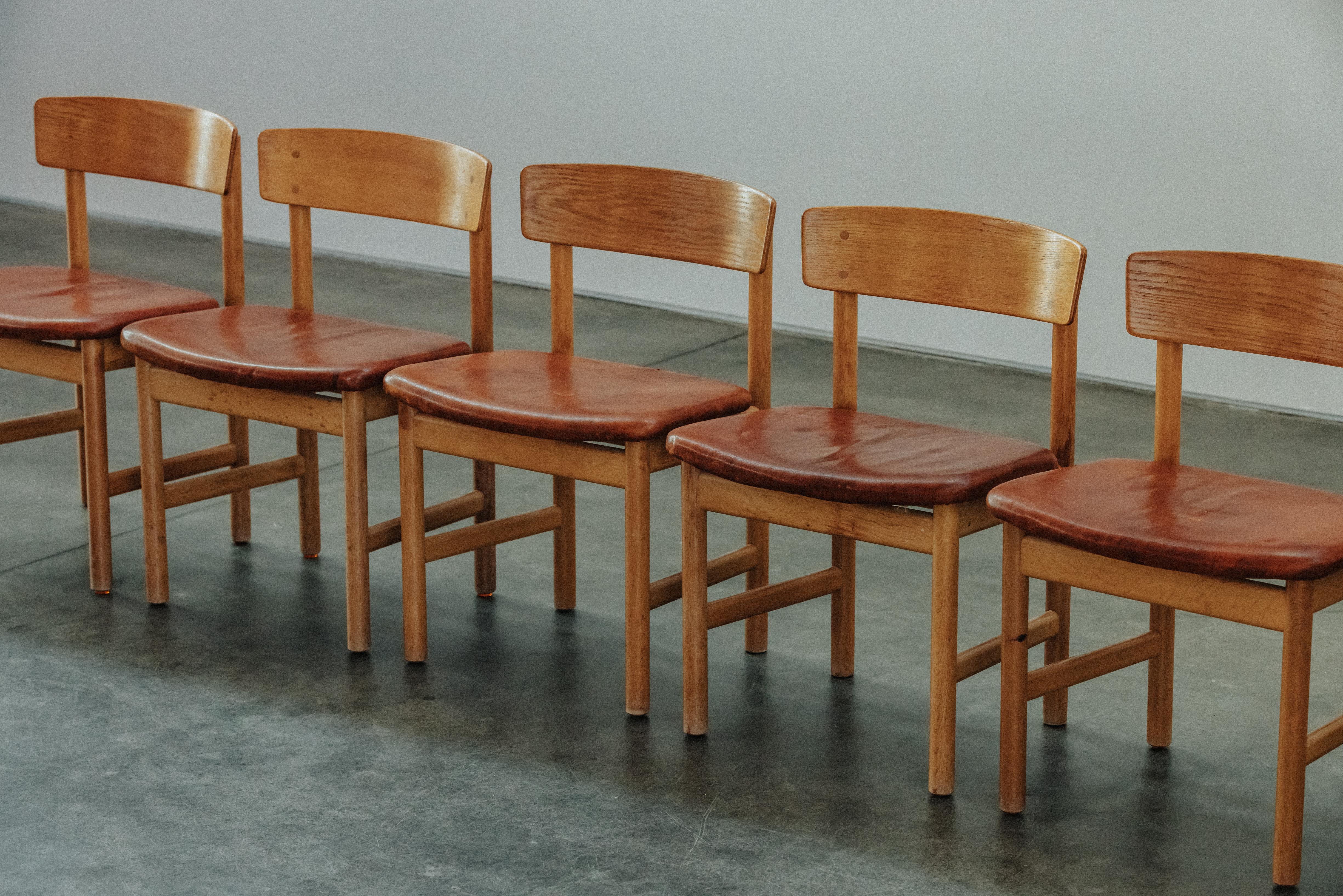 Vintage Set von Borge Mogensen Esszimmerstühle aus Dänemark, CIRCA 1970.  Eiche aus mit originalen cognacfarbenen Ledersitzen.  Altersbedingte Abnutzung und Gebrauch.