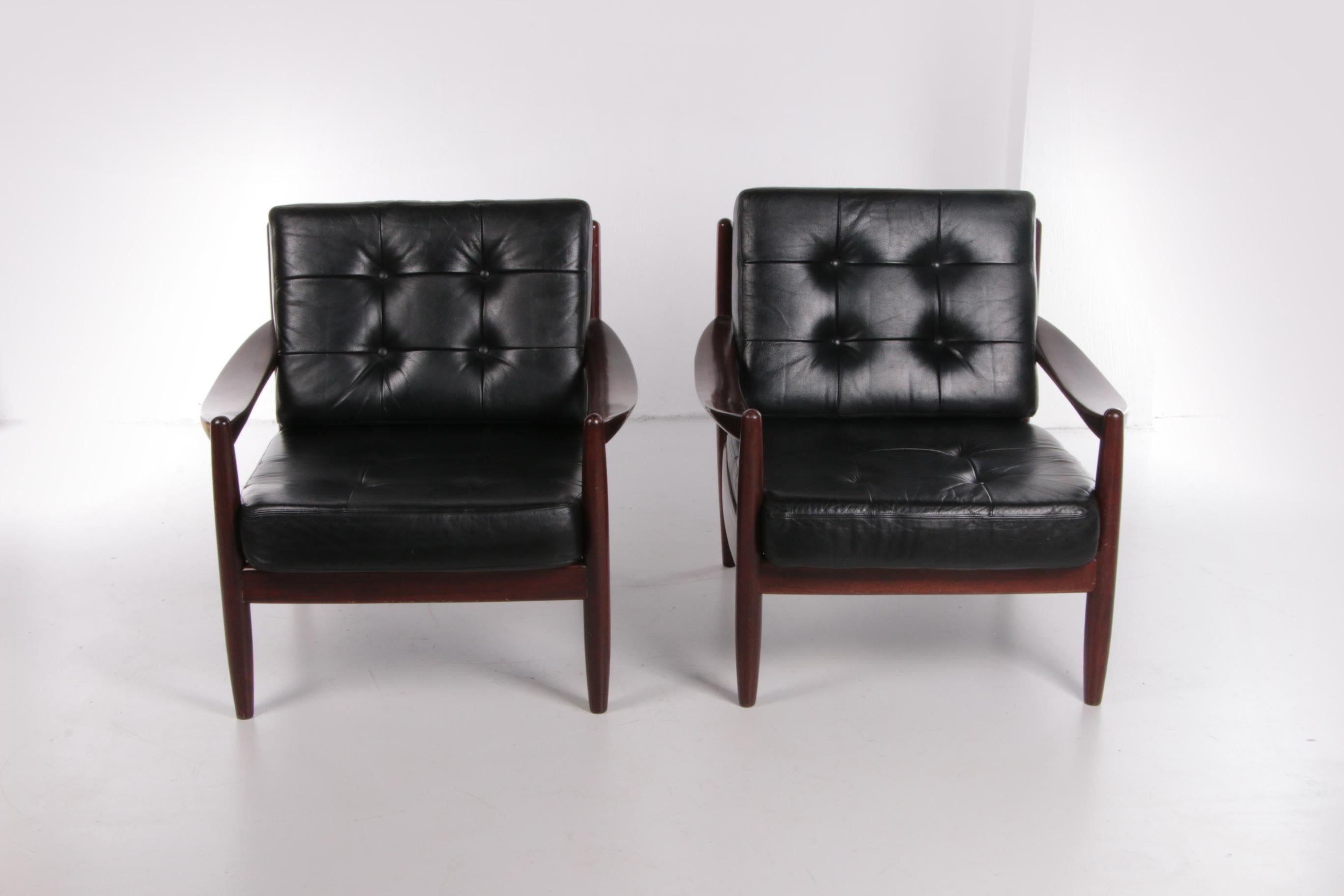 Un ensemble vintage de deux beaux fauteuils en bois foncé. Les deux chaises ont un design scandinave simple et luxueux.

Les fauteuils ont été produits dans les années 1960 et proviennent du Danemark.

Les chaises sont composées de cuir noir