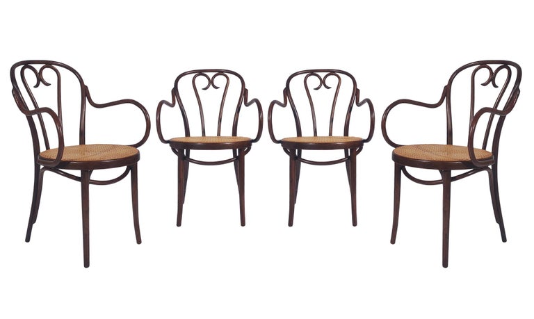 A nice matching set of eight bistro chairs from the 1950s by Thonet marked made in Poland. These armchairs feature solid bentwood frames with caned seats. All in very good condition and damage free condition.
