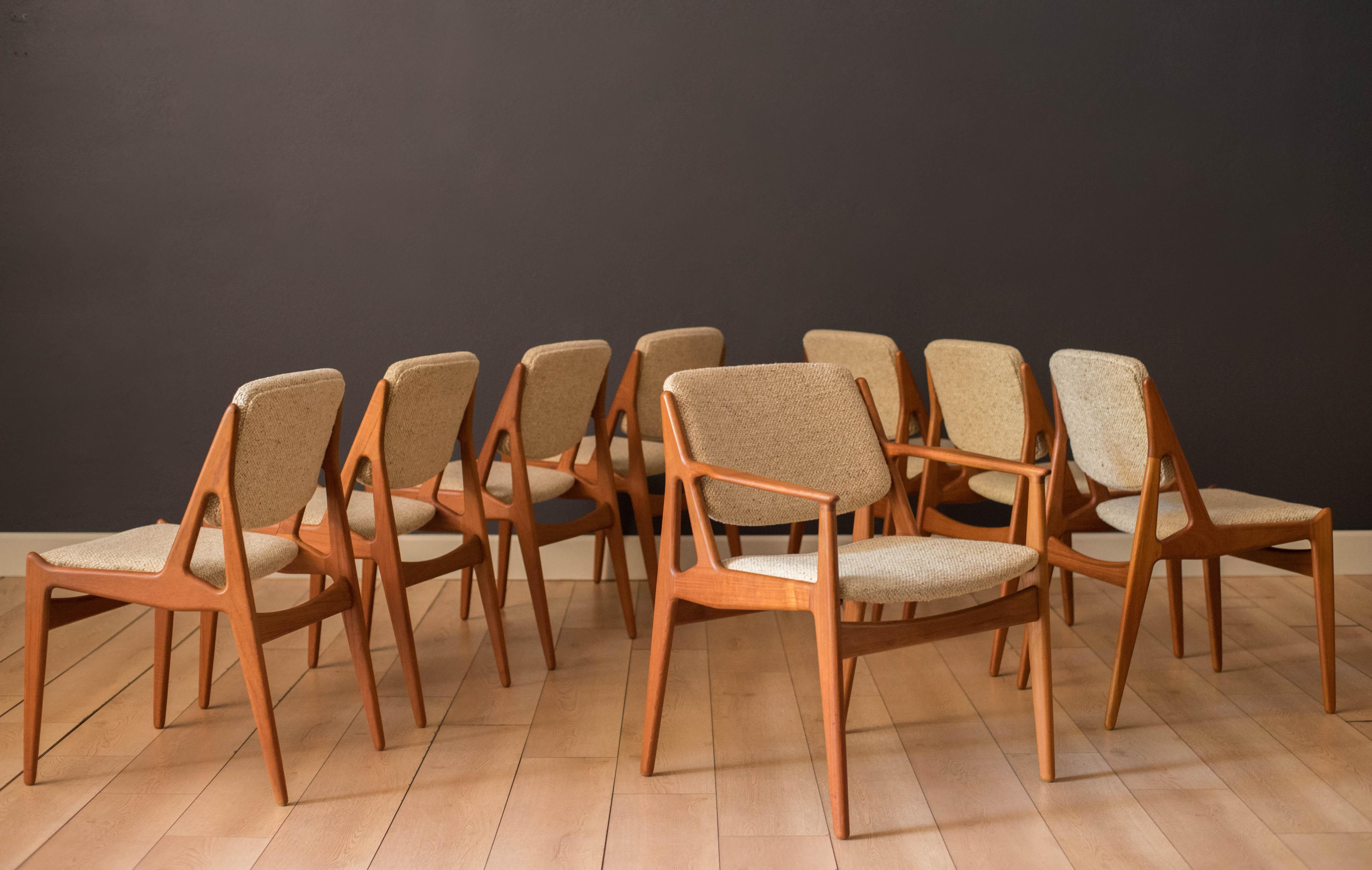 Mid century modern set of eight 'Ella' dining chairs designed by Arne Vodder for Vamo Sonderborg, circa 1960's. Features sculptural solid teak frames and a unique swivel tilting backrest in an oatmeal tweed fabric. The set includes seven side chairs