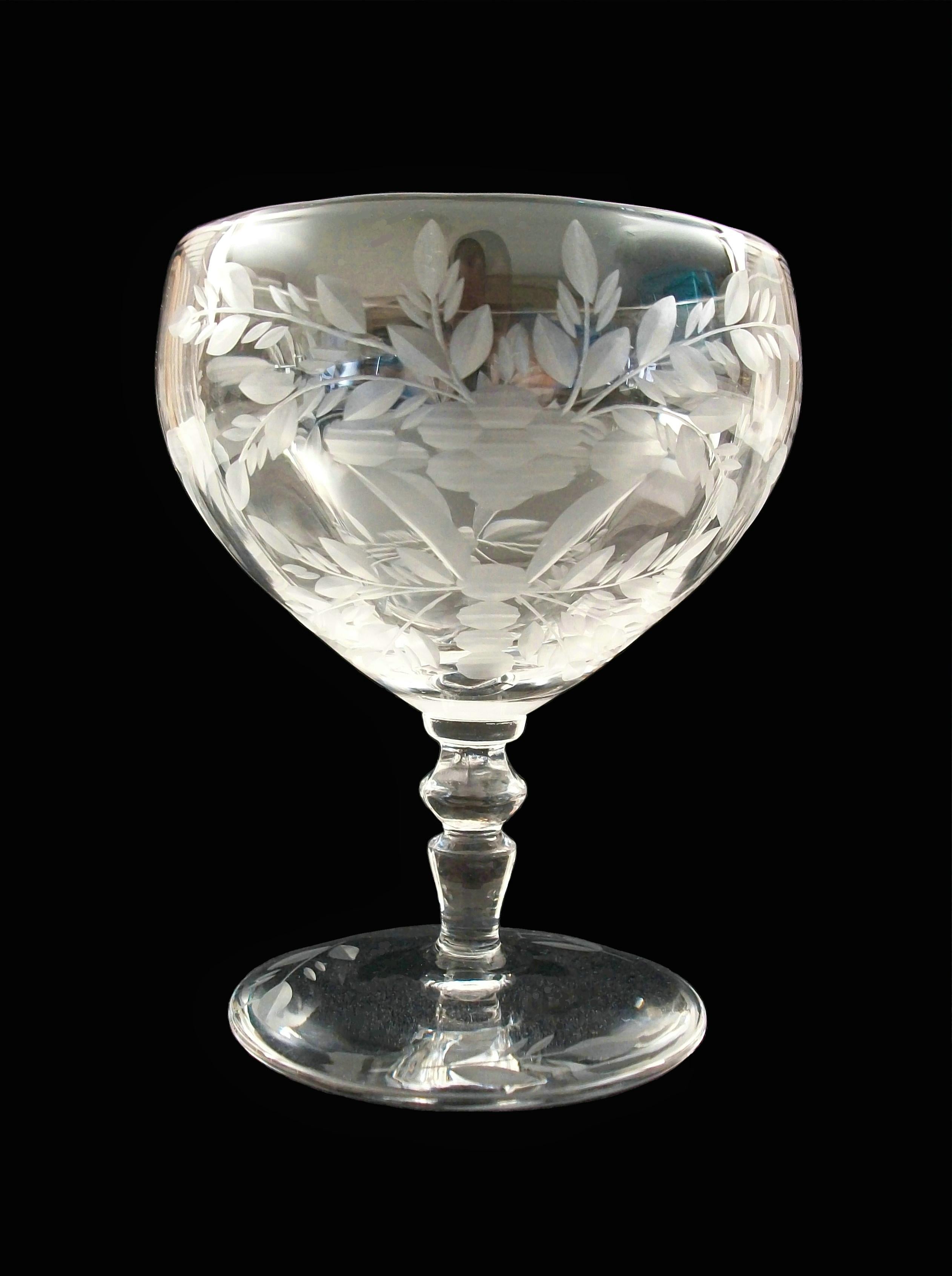 Vintage set of exceptional crystal Champagne coupes - eight pieces - wheel cut by hand featuring flowers and garlands of leaves - branches with leaves to the base - clear crystal - polished finish - unsigned - circa 1930's.

Excellent état vintage -