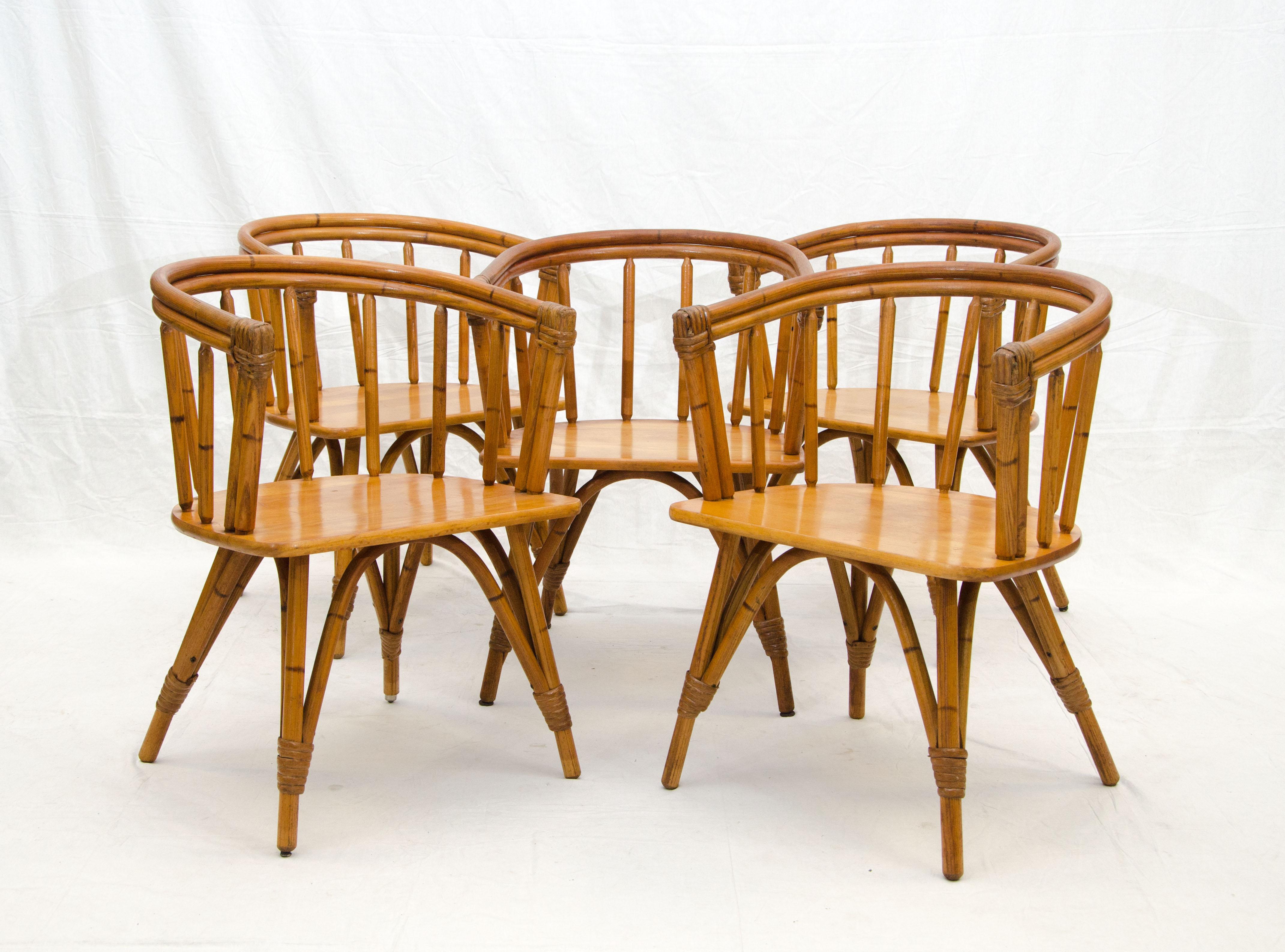 Set of five Heywood Wakefield captains chairs from their Ashcraft line which was made to look like the legs and backs were rattan, with paper cord wrapping at the fronts of the arms as well as the legs. The wrappings were decorative accents. These