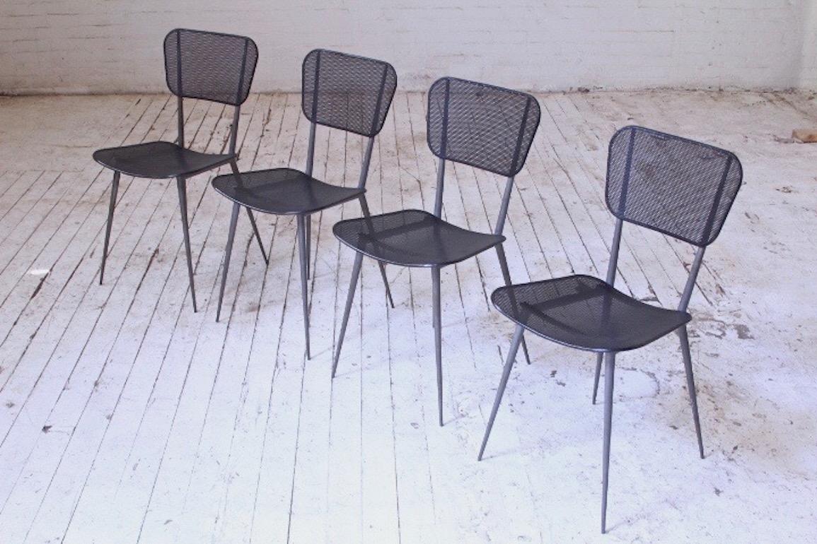 Striking set of four vintage dining chairs attributed to Mathieu Matégot in his trademark perforated and lacquered sheet steel. Wonderful lightness to these, masterful use of steel enables these chairs to be light and refined looking yet strong, and