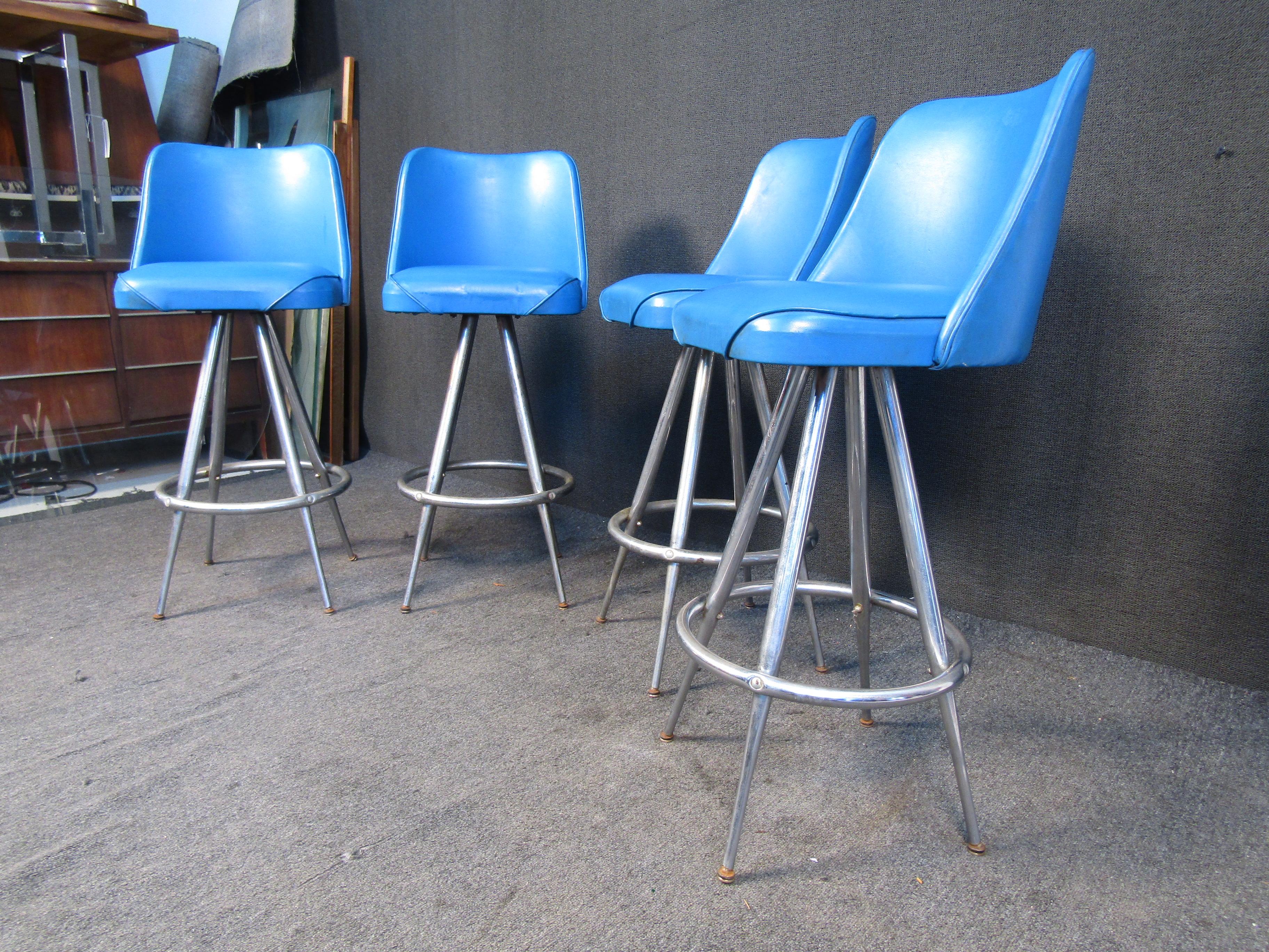 This vintage set of bar stools can brighten up any space through their bright blue upholstery. Metal bases add a crafted and sturdy Mid-Century quality to the stools. Please confirm item location with seller (NY/NJ).