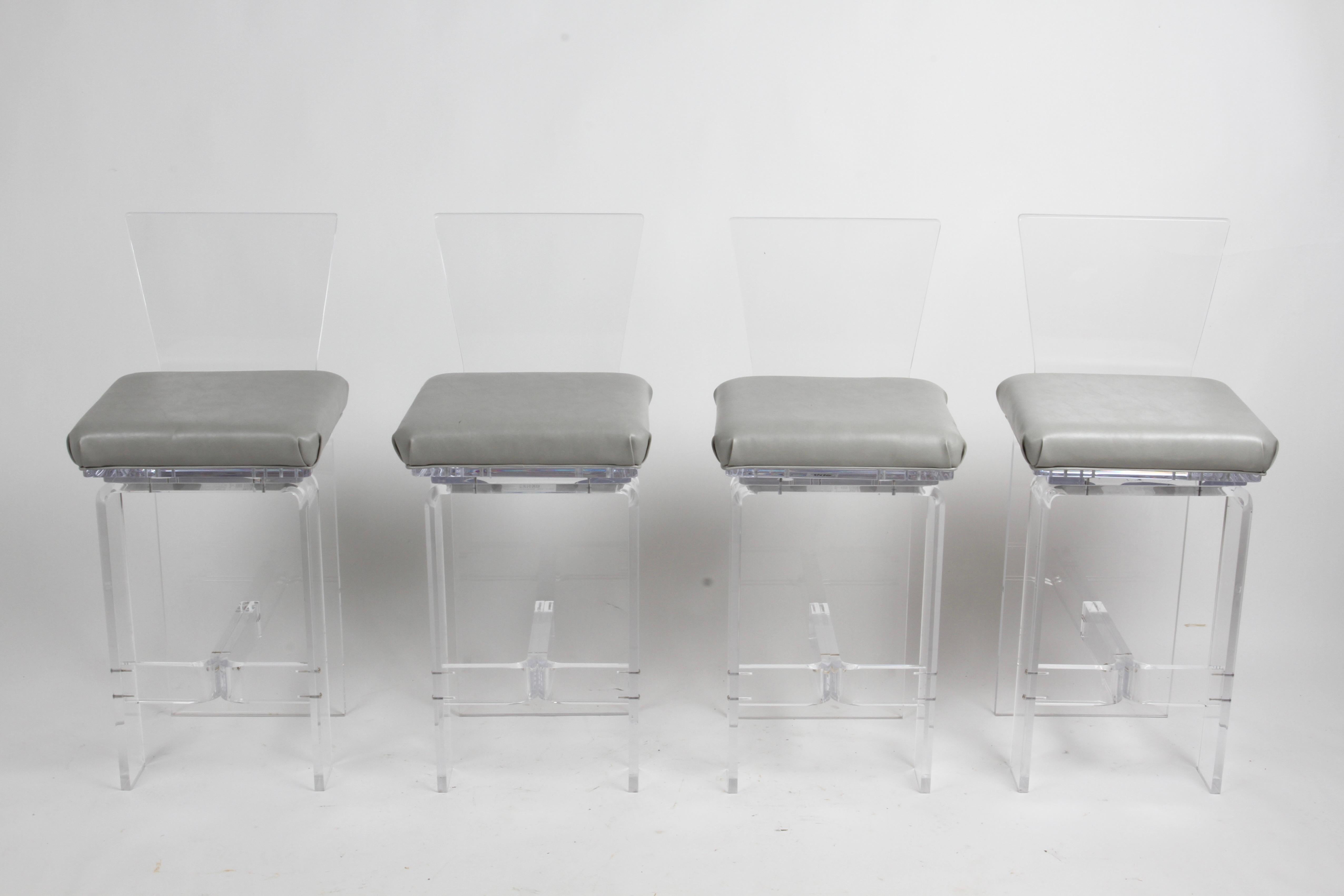 Vintage 1980 Hollywood Regency style set of four Acrylic 360° swivel bar stools with high backs, footrest and grey vinyl padded seats by AKKO INC. En très bon état d'origine, aucun dommage, seulement quelques petites éraflures. Dans le style de