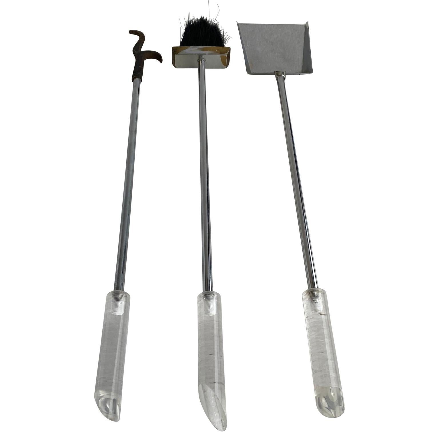 Set of Mid-Century Modern Lucite and chrome fireplace tools.
This modern set of fireplace tools has a polished chrome base and a center stalk with polished lucite tool handles. In vintage condition, this set is a wonderful addition to any modern
